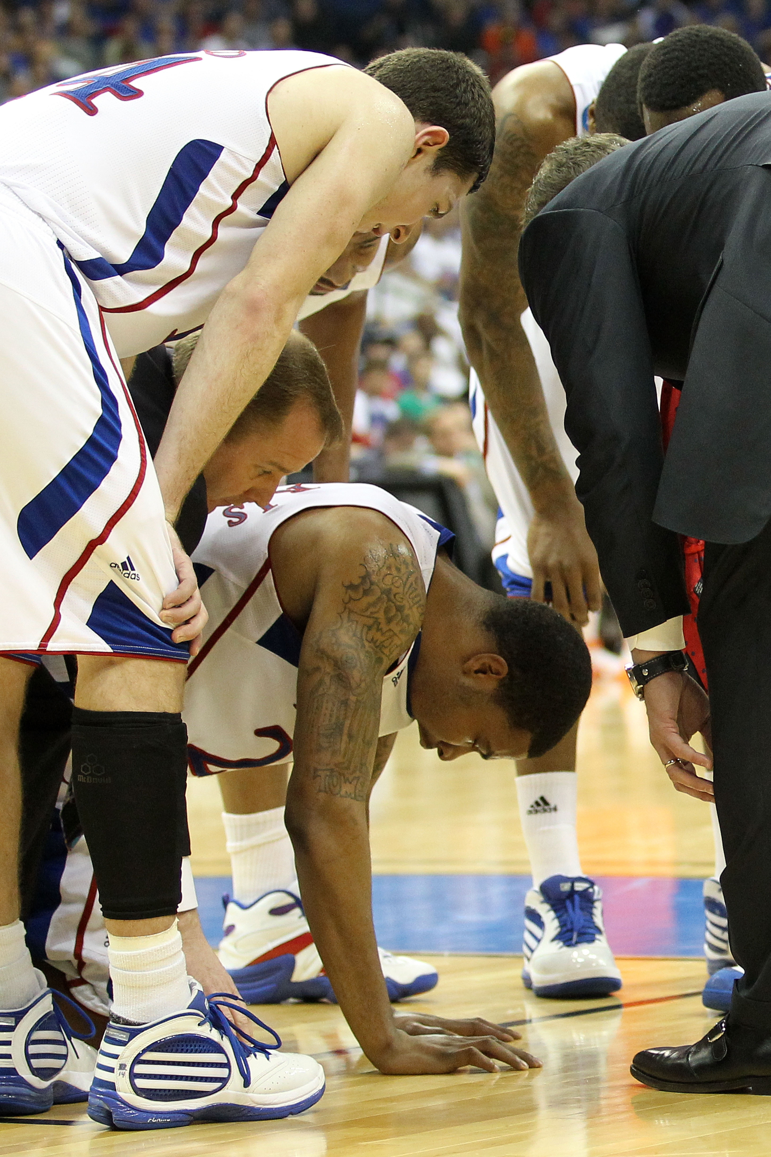 TULSA, OK - MARCH 20:  (Center) Marcus Morris #22 of the Kansas Jayhawks is surrounded by team members on the court after a play against the Illinois Fighting Illini during the third round of the 2011 NCAA men's basketball tournament at BOK Center on Marc