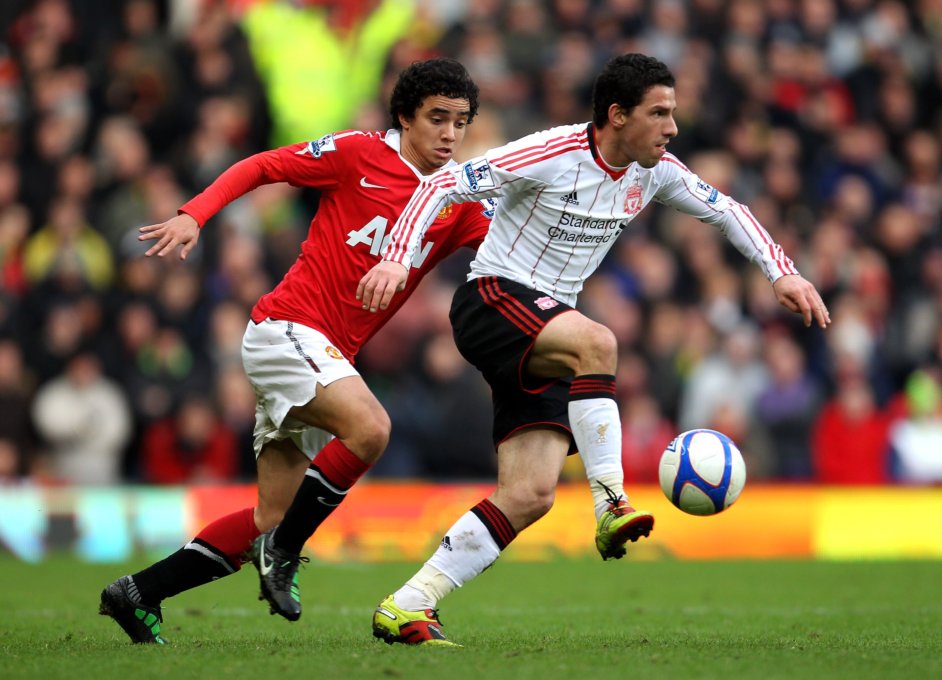 MANCHESTER, ENGLAND - JANUARY 09:  Rafael of Manchester United competes with Maxi Rodriguez of Liverpool during the FA Cup sponsored by E.ON 3rd round match between Manchester United and Liverpool at Old Trafford on January 9, 2011 in Manchester, England.