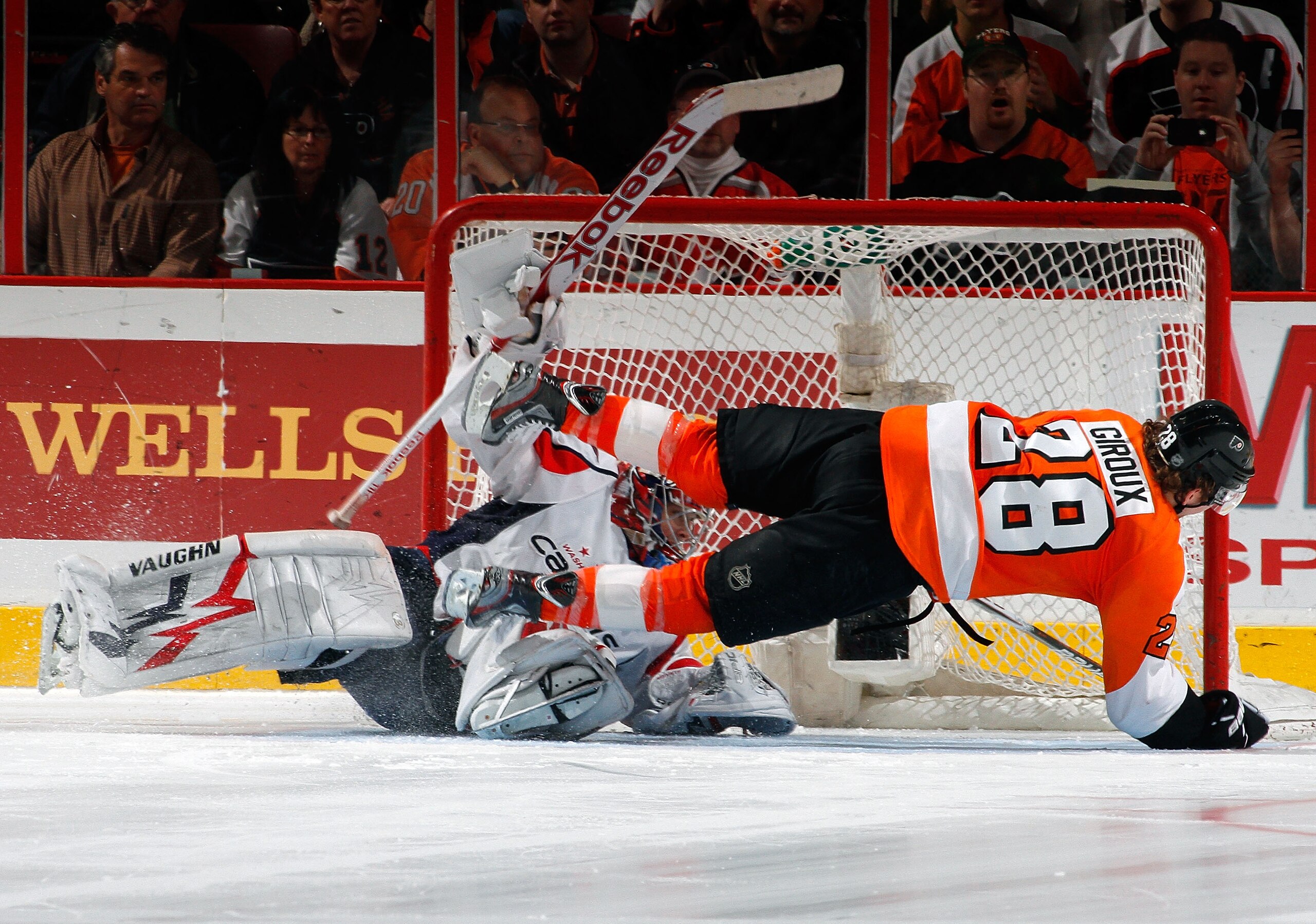 PHILADELPHIA, PA - MARCH 22:  Goalie Michal Neuvirth #30 of the Washington Capitals stops the shot by Claude Giroux #28 of the Philadelphia Flyers and sends him flying during the shootout in an NHL hockey game at the Wells Fargo Center on March 22, 2011 i