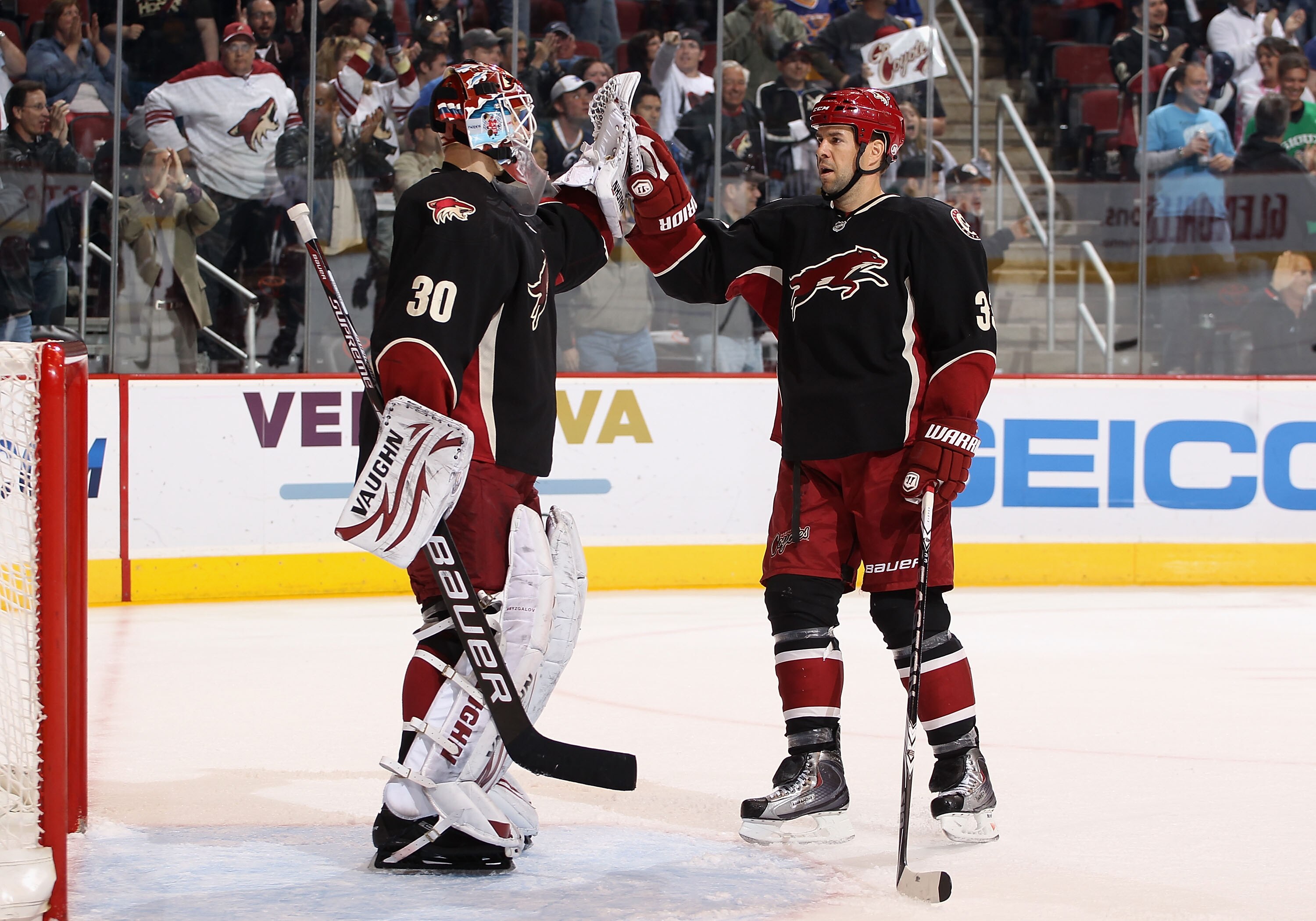 GLENDALE, AZ - MARCH 22:  Goaltender Ilya Bryzgalov #30 of the Phoenix Coyotes is congratulated by teammate Adrian Aucoin #33 after defeating the St. Louis Blues in the NHL game at Jobing.com Arena on March 22, 2011 in Glendale, Arizona. The Coyotes defea