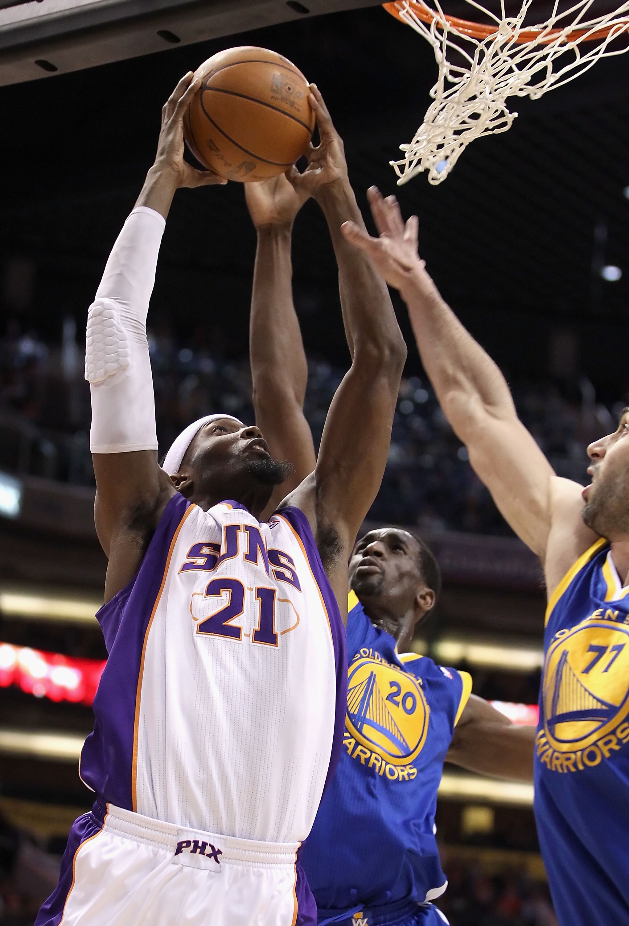 PHOENIX, AZ - FEBRUARY 10:  Hakim Warrick #21 of the Phoenix Suns attempts a shot against Ekpe Udoh #20 and Vladimir Radmanovic #77 of the Golden State Warriors during the NBA game at US Airways Center on February 10, 2011 in Phoenix, Arizona. The Suns de