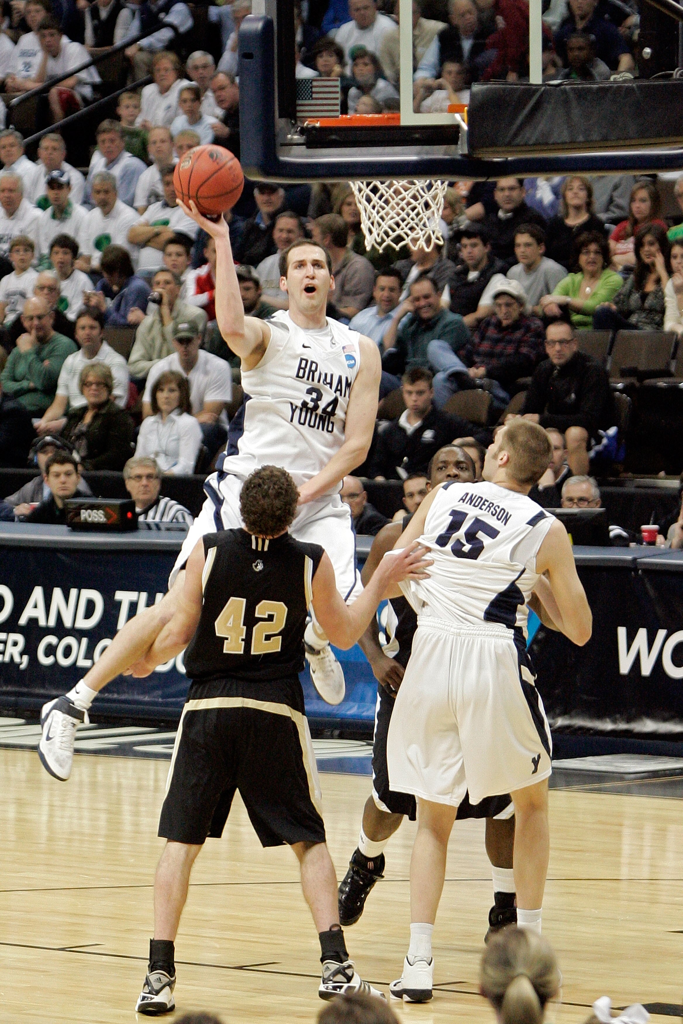 DENVER, CO - MARCH 17:  Noah Hartsock #34 of the Brigham Young Cougars goes to the hoops against Noah Dahlman #42 of the Wofford Terriers during the second round of the 2011 NCAA men's basketball tournament at Pepsi Center on March 17, 2011 in Denver, Col