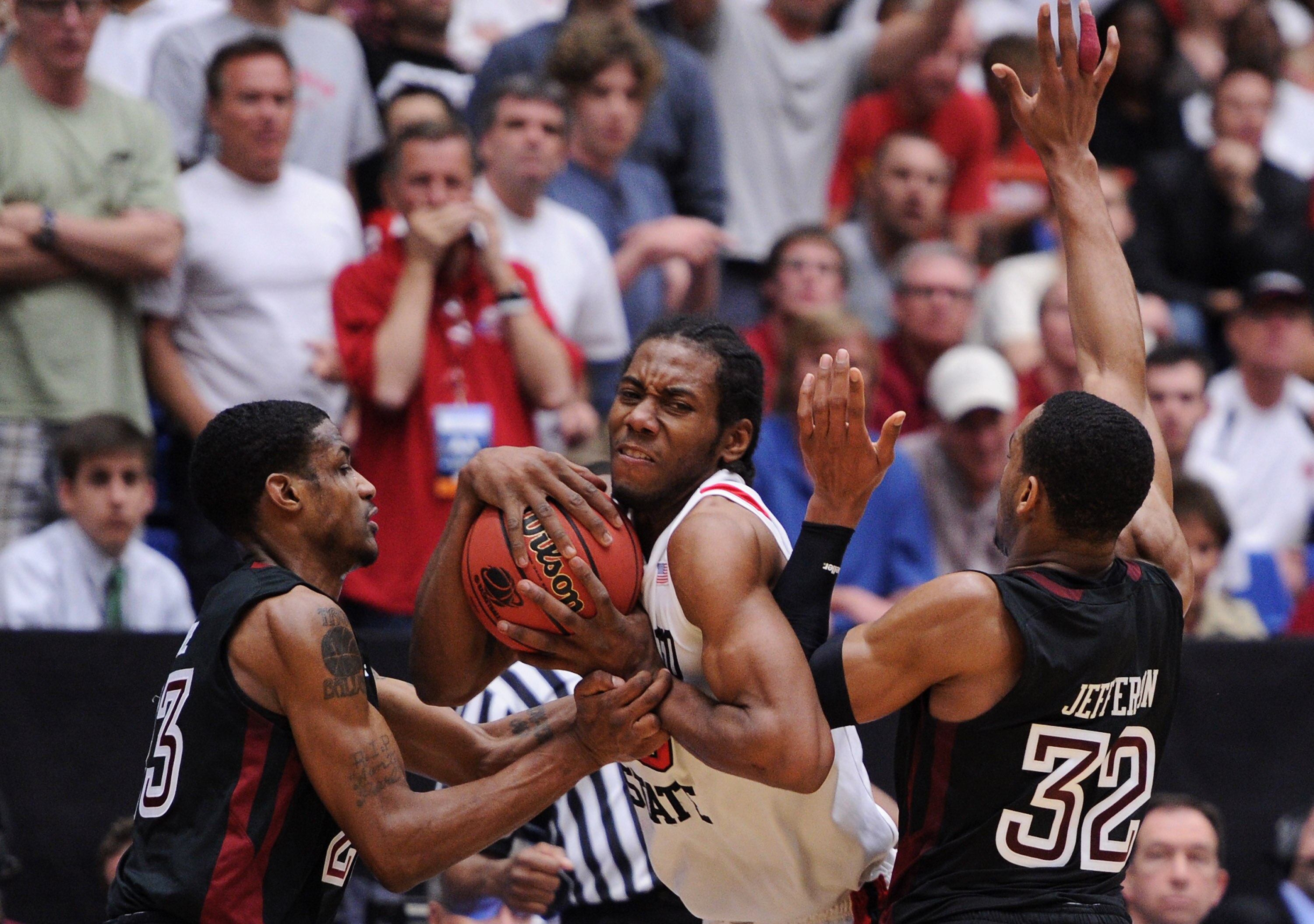 TUCSON, AZ - MARCH 19:  Ramone Moore #23 and Rahlir Jefferson #32 of the Temple Owls attempt to steal from Kawhi Leonard #15 of the San Diego State Aztecs in double overtime during the third round of the 2011 NCAA men's basketball tournament at McKale Cen