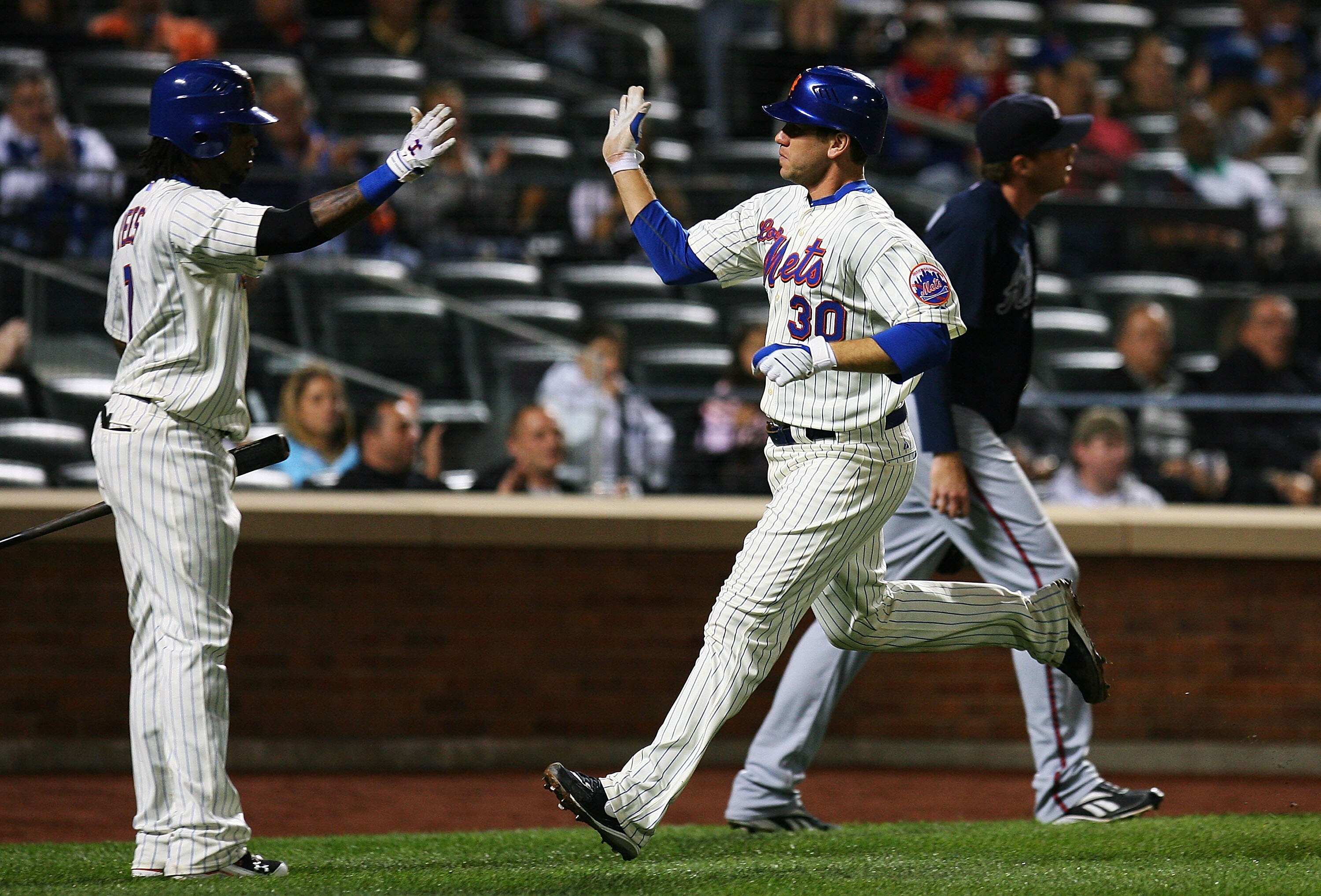 NEW YORK - SEPTEMBER 17:  Josh Thole #30 (R) of the New York Mets high fives  Jose Reyes #7 after scoring a run in the second inning against the Atlanta Braves on September 17, 2010 at Citi Field in the Flushing neighborhood of the Queens borough of New Y