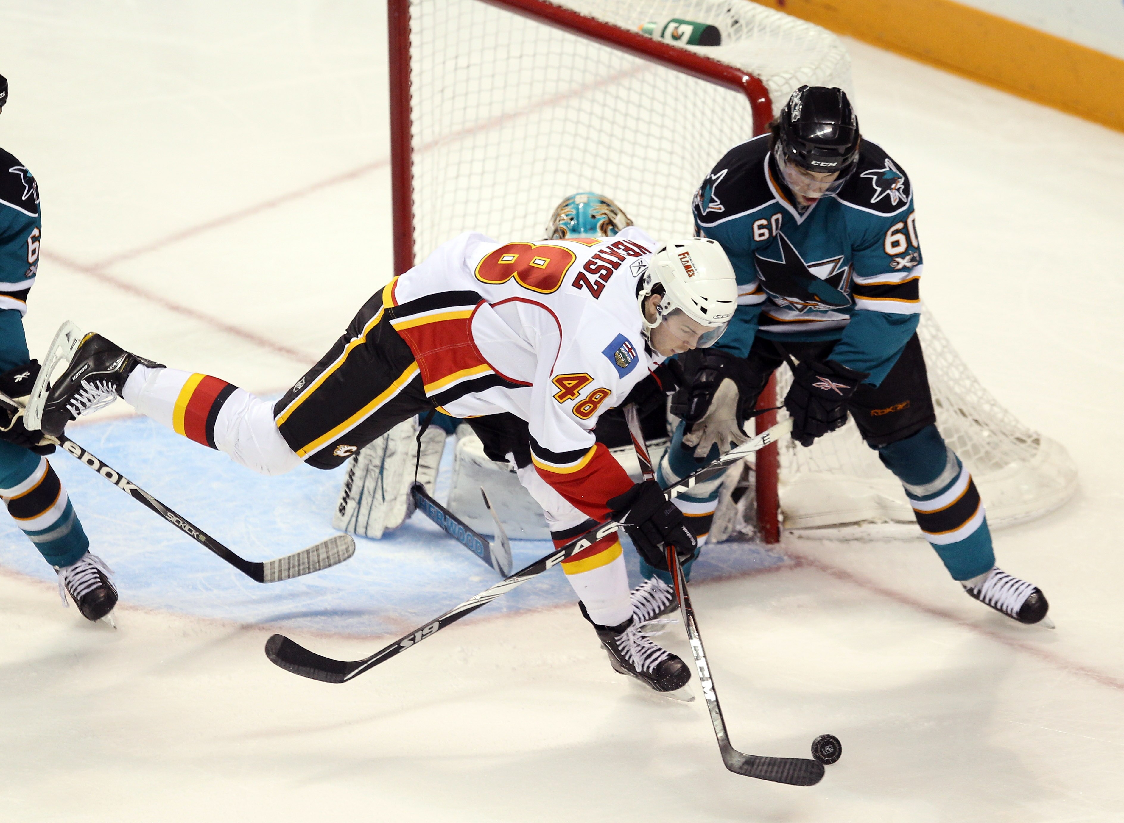 SAN JOSE, CA - MARCH 23: Greg Nemisz #48 of the Calgary Flames and Jason Demers #60 of the San Jose Sharks go for the puck at the HP Pavilion on March 23, 2011 in San Jose, California.  This was Nemisz' first NHL game.  (Photo by Ezra Shaw/Getty Images)