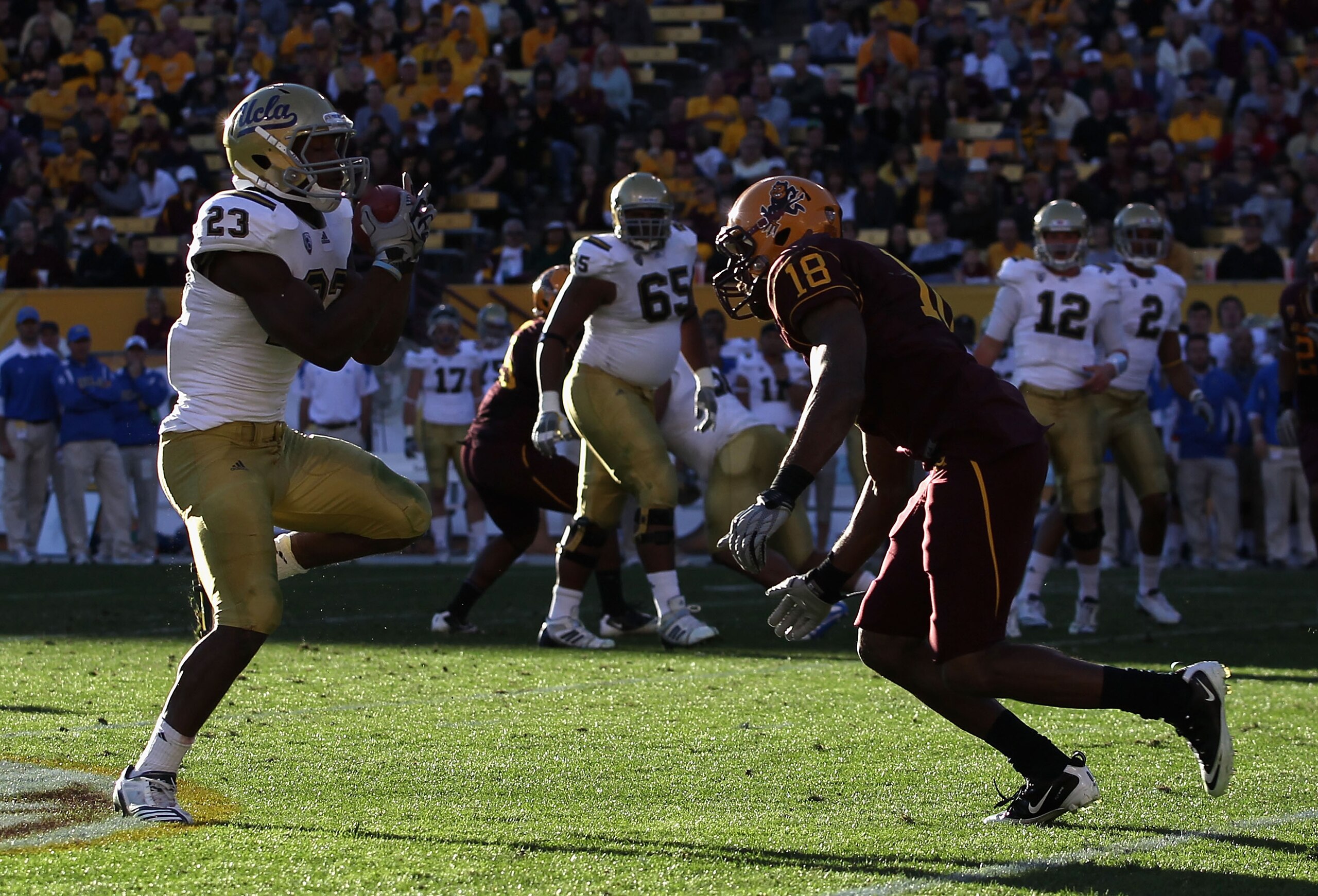 TEMPE, AZ - NOVEMBER 26:  Tailback Johnathan Franklin #23 of the UCLA Bruins runs with the ball after a reception against Oliver Aaron #18 of the Arizona State Sun Devils during the college football game at Sun Devil Stadium on November 26, 2010 in Tempe,