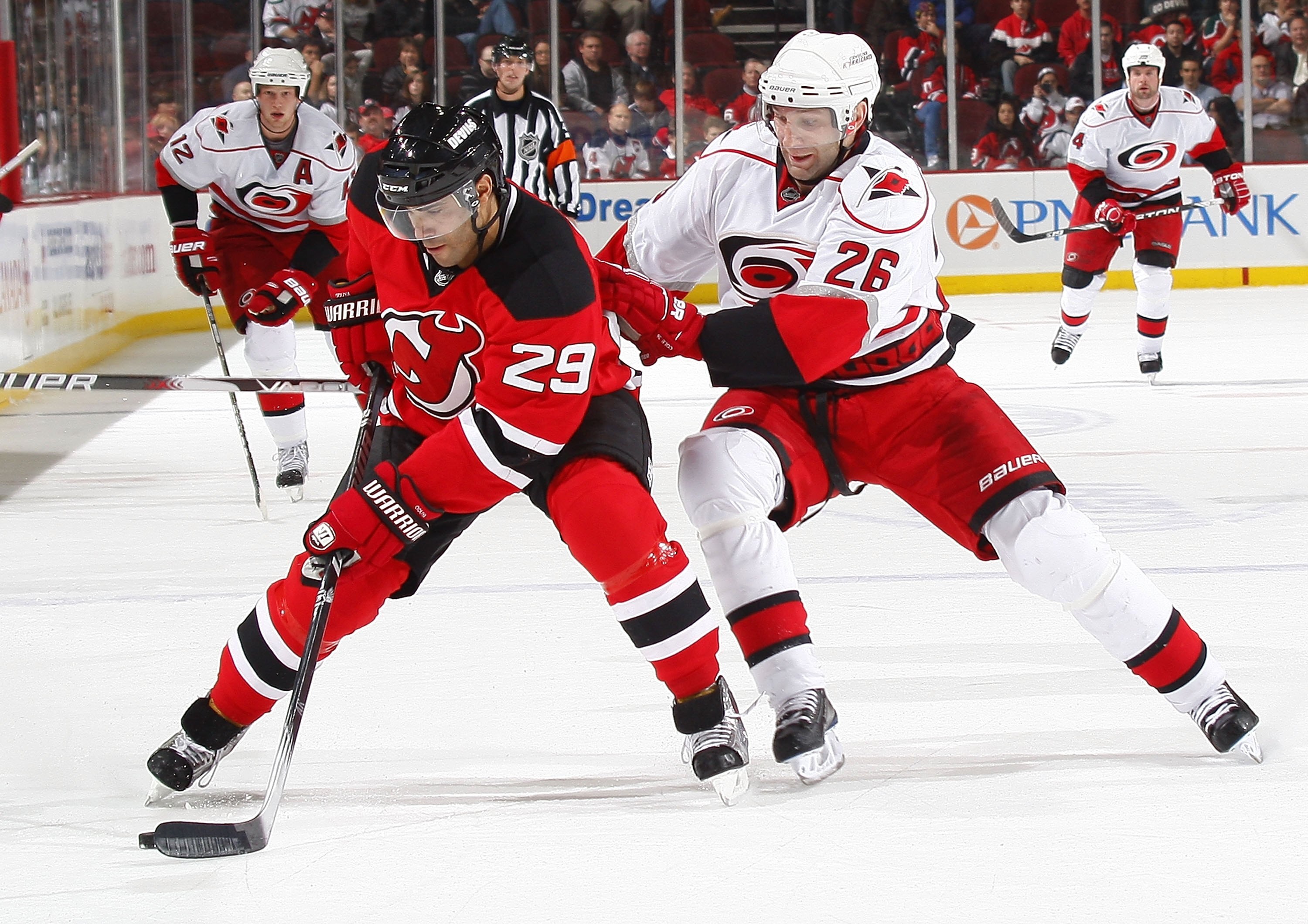 NEWARK, NJ - DECEMBER 09:  Erik Cole #44 of the Carolina Hurricanes checks Johnny Oduya #29 of the New Jersey Devils on December 9, 2009 in Newark, New Jersey.  (Photo by Paul Bereswill/Getty Images)