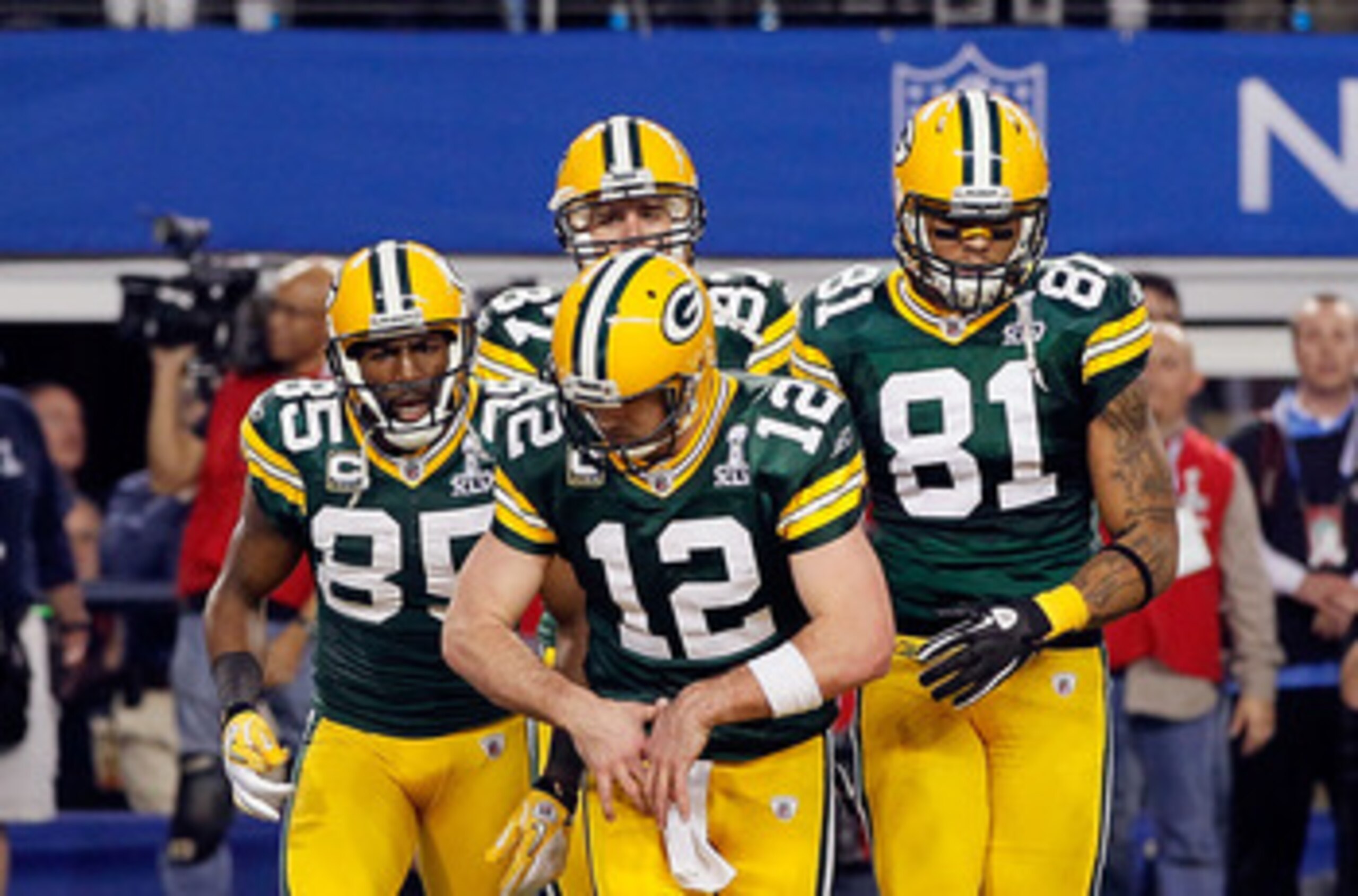 ARLINGTON, TX - FEBRUARY 06:  Aaron Rodgers #12 of the Green Bay Packers gestures putting on a championship belt as he celebrates a Green Bay touchdown against the Pittsburgh Steelers during Super Bowl XLV at Cowboys Stadium on February 6, 2011 in Arlingt