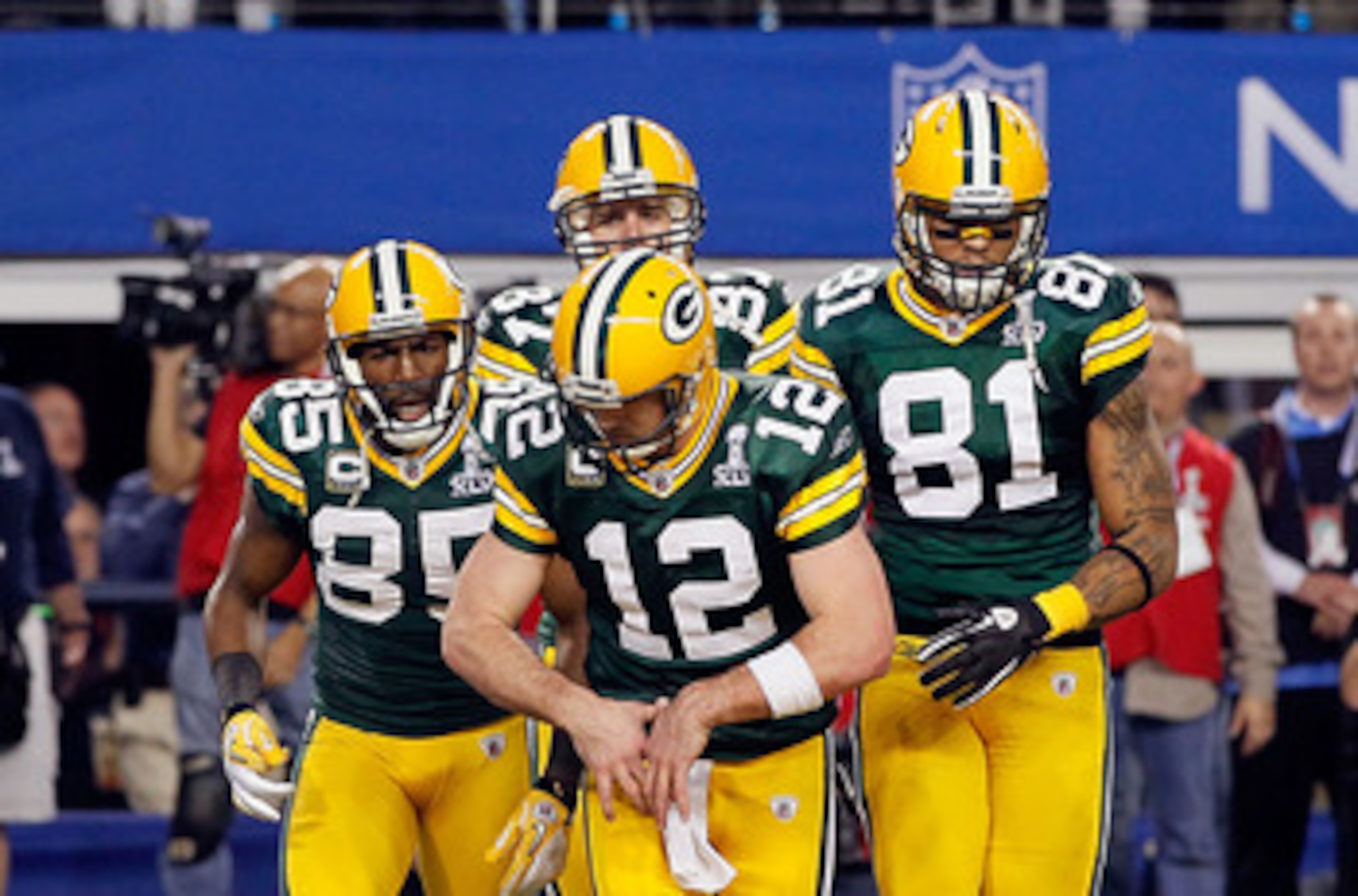 ARLINGTON, TX - FEBRUARY 06:  Aaron Rodgers #12 of the Green Bay Packers gestures putting on a championship belt as he celebrates a Green Bay touchdown against the Pittsburgh Steelers during Super Bowl XLV at Cowboys Stadium on February 6, 2011 in Arlingt