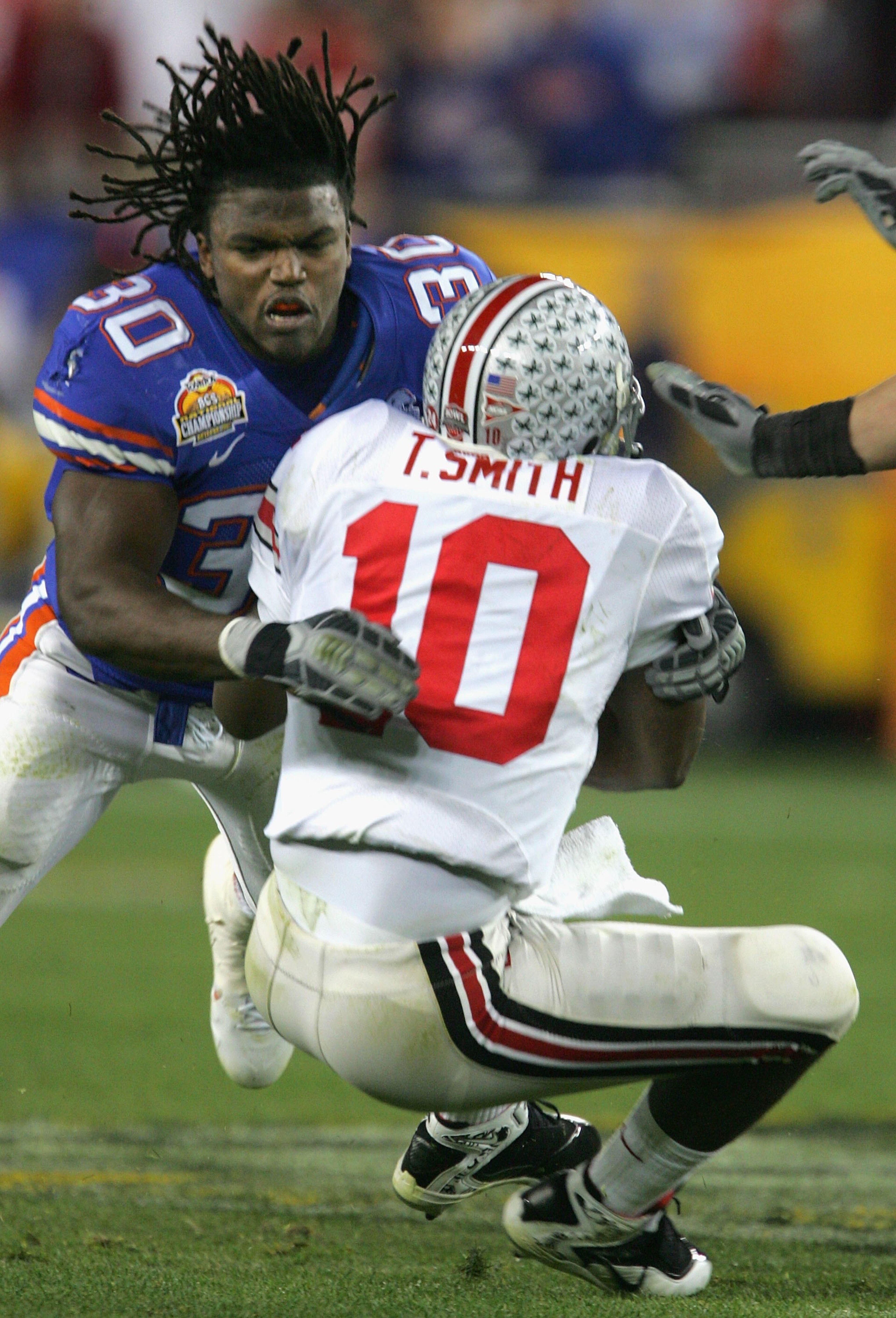 GLENDALE, AZ - JANUARY 08:  Linebacker Earl Everett #30 of the Florida Gators tackles Troy Smith #10 of the Ohio State Buckeyes after losing his helmet during the 2007 Tostitos BCS National Championship Game at the University of Phoenix Stadium on January