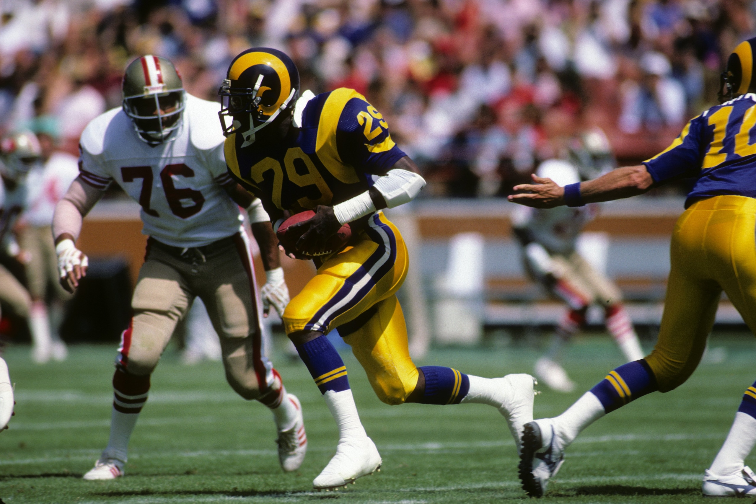 ANAHEIM, CA - SEPTEMBER 14:  Running back Eric Dickerson #28 of the Los Angeles Rams runs with the ball against defensive back Dwaine Board #76 of the San Francisco 49ers during the game at Anaheim Stadium on September 14, 1986 in Anaheim, California.   T