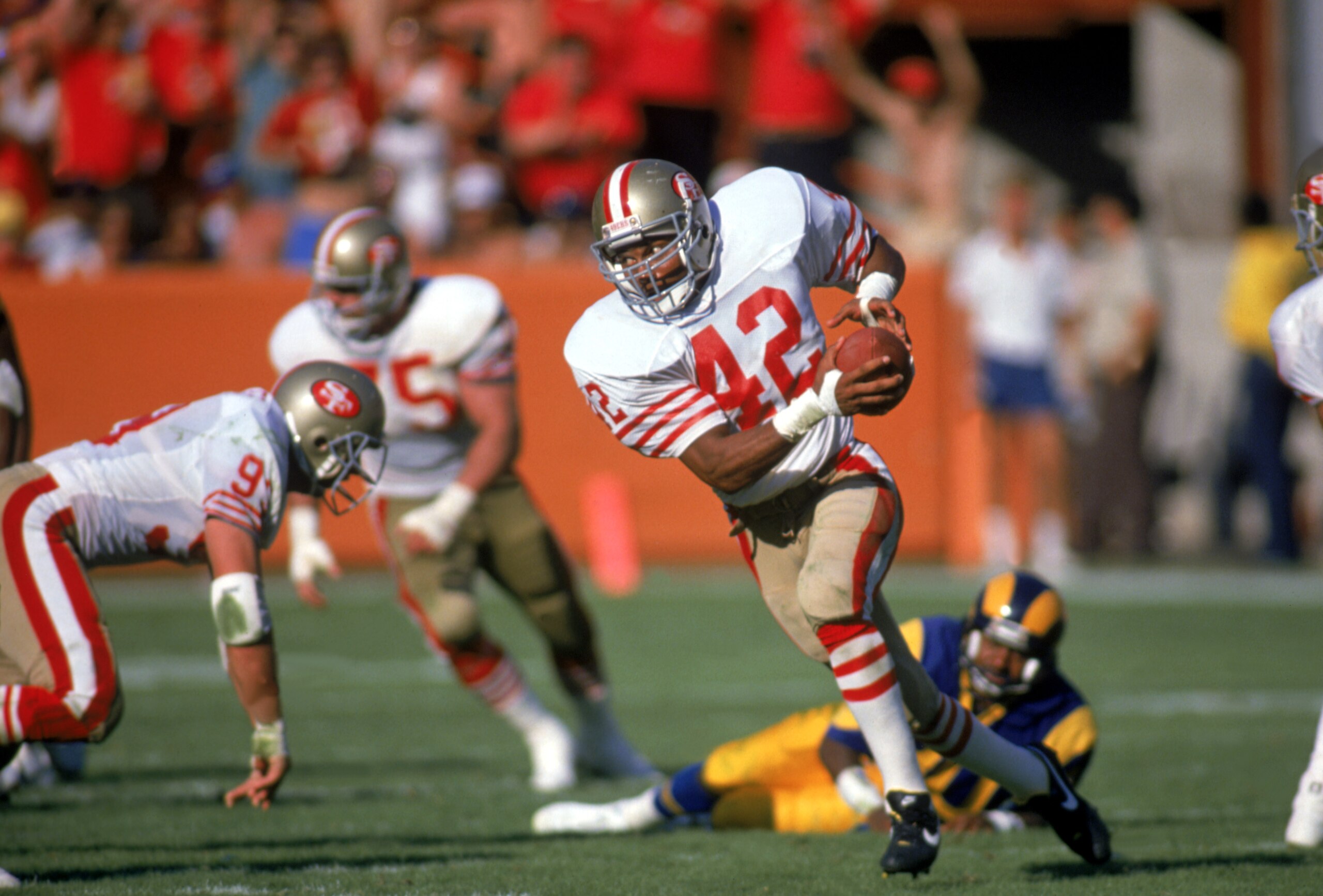 SAN FRANCISCO - 1989:  Defenseman Ronnie Lott #42 of the San Francisco 49ers runs the ball against the Los Angeles Rams during a game at Candlestick Park during the 1989 NFL season in San Francisco, California.  (Photo by Stephen Dunn/Getty Images)