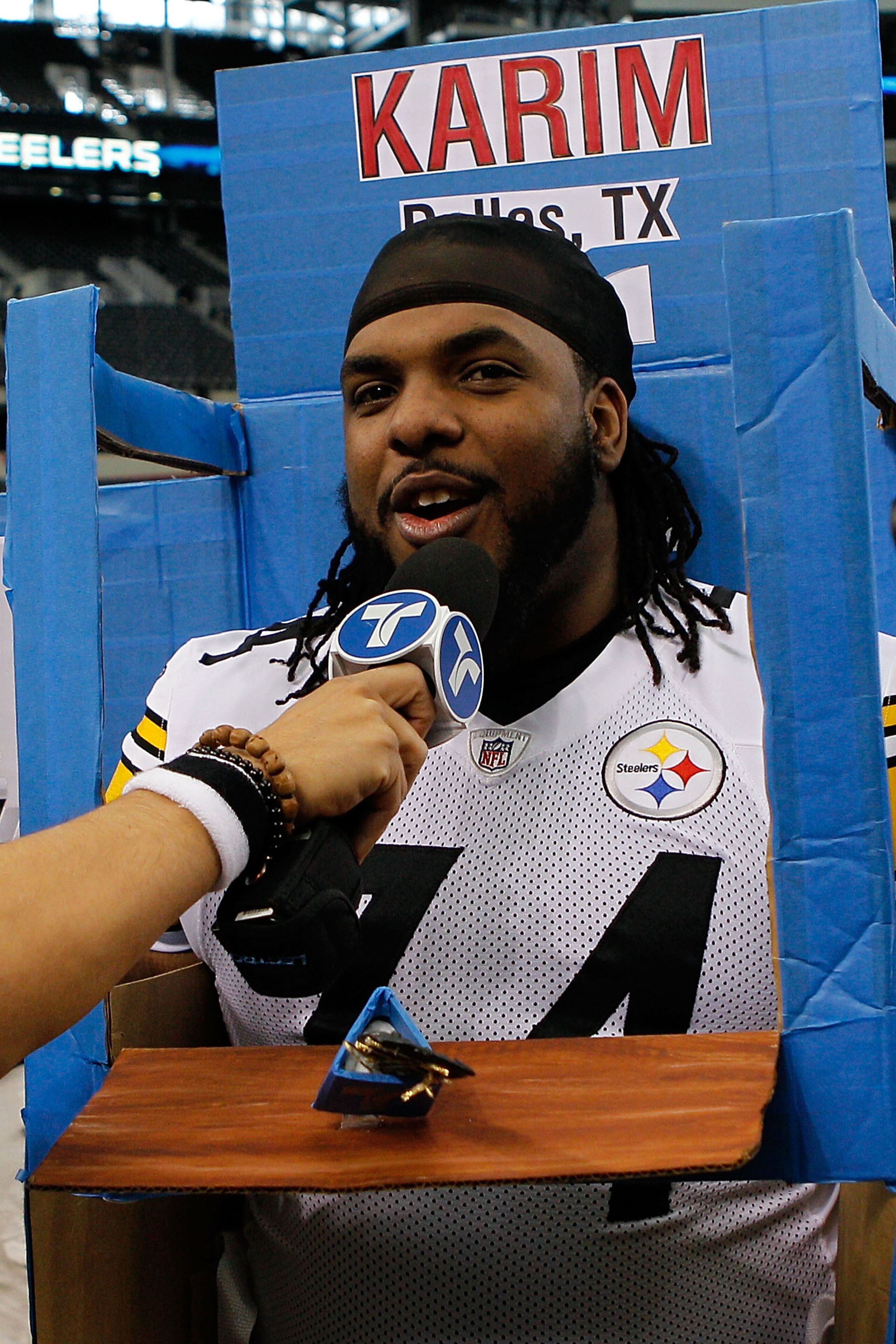 ARLINGTON, TX - FEBRUARY 01:  Willie Colon #74 of the Pittsburgh Steelers gets into a box brought in by a member of Telemundo during Super Bowl XLV Media Day ahead of Super Bowl XLV at Cowboys Stadium on February 1, 2011 in Arlington, Texas. The Pittsburg
