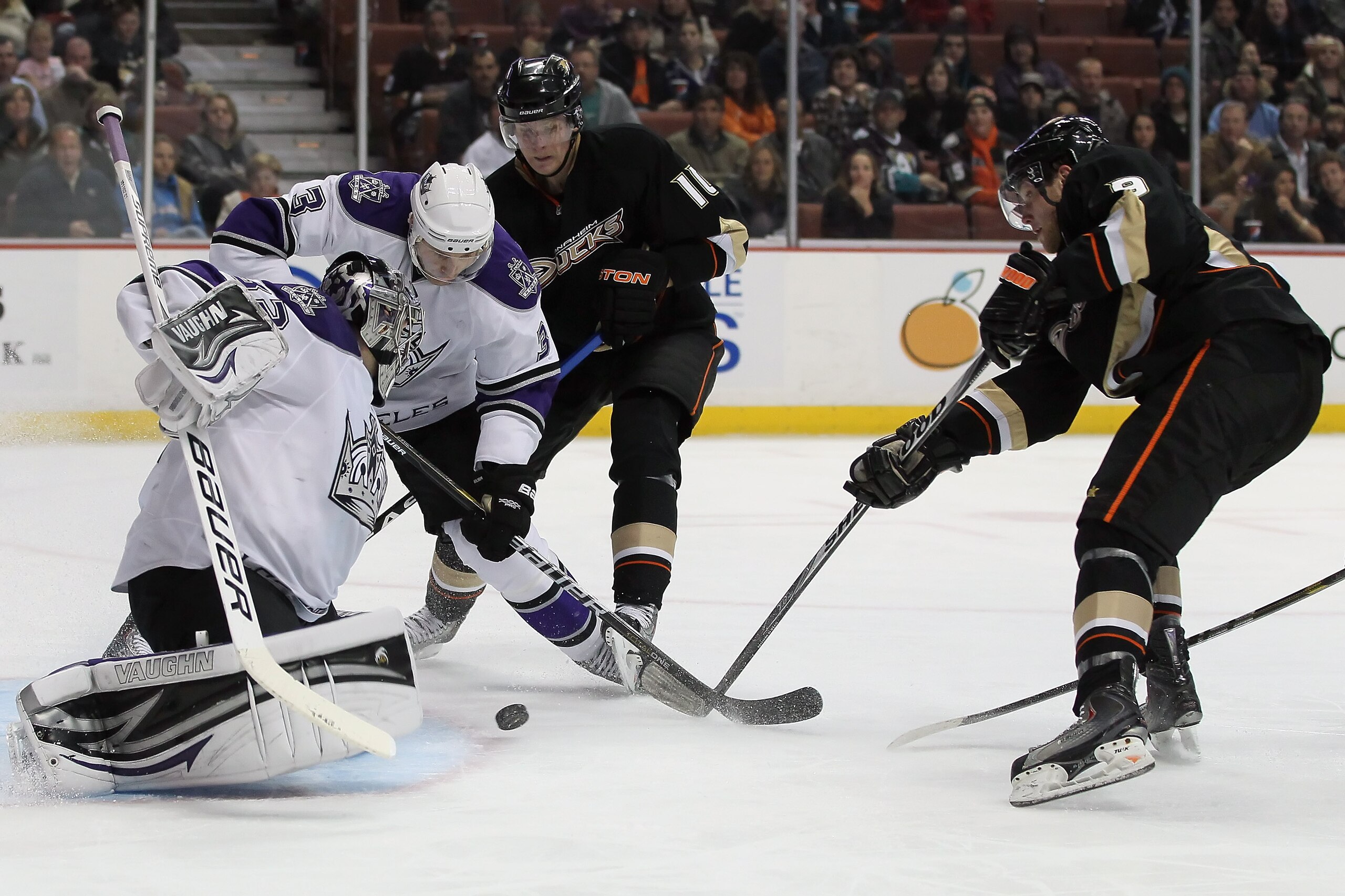 ANAHEIM, CA - NOVEMBER 29:  (L-R) Goaltender Jonathan Quick #32 of the Los Angeles Kings makes a save, as teammate Jack Johnson #3 defends the puck from Corey Perry #10 and Bobby Ryan #9 of the Anaheim Ducks during the third period at the Honda Center on