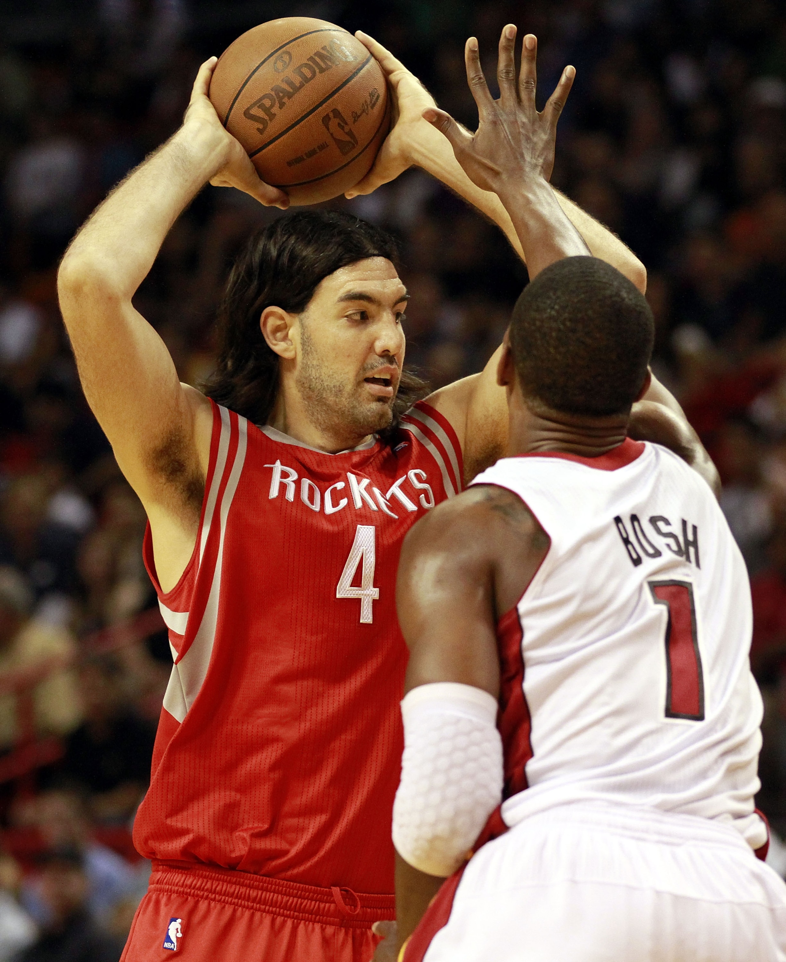 MIAMI, FL - MARCH 27:  Forward Chris Bosh #1 of the Miami Heat defends against Forward Luis Scola #4 of the Houston Rockets at American Airlines Arena on March 27, 2011 in Miami, Florida. NOTE TO USER: User expressly acknowledges and agrees that, by downl