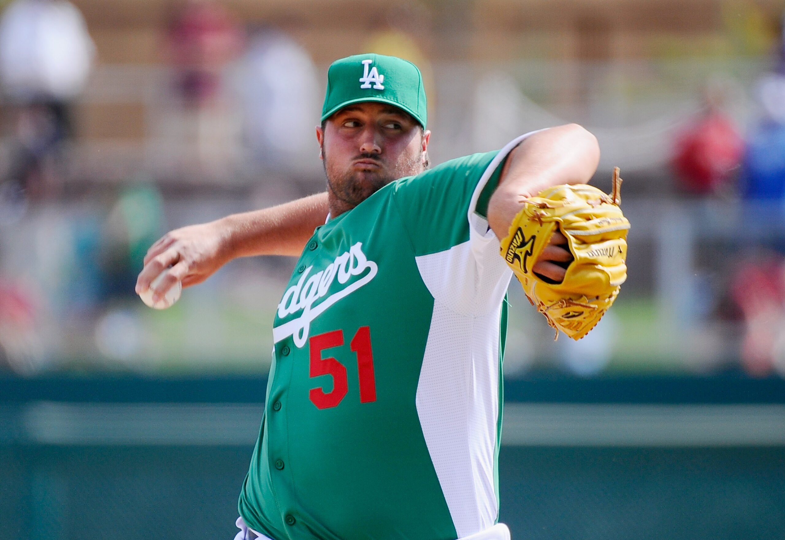 GLENDALE, AZ - MARCH 17:  Pitcher Jonathan Broxton #51 of the Los Angeles Dodgers wearing a green jersey in celebration of St. Patrick's Day throws a pitch against the Arizona Diamondbacks during the spring training baseball game on March 17, 2011 in Glen