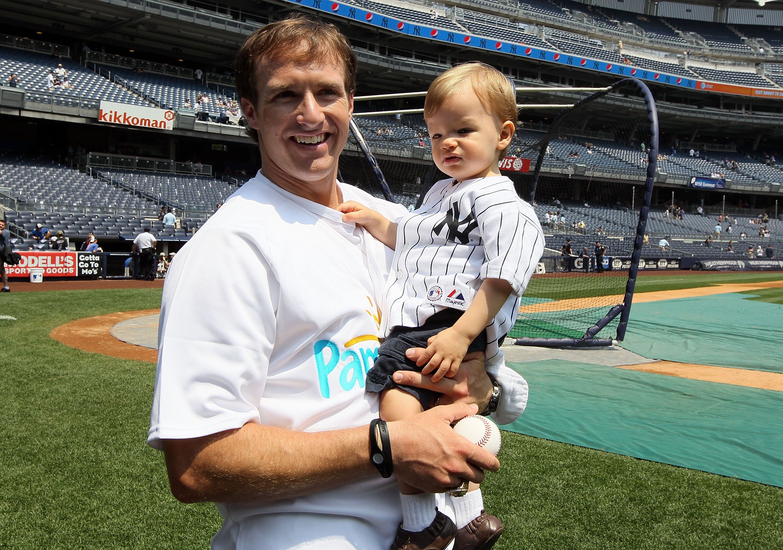 NEW YORK - JUNE 20:  Super Bowl XLIV MVP Drew Brees of the New Orleans Saints stands on the field with his son Baylen prior to the the New York Yankees game against the New York Mets on June 20, 2010 at Yankee Stadium in the Bronx borough of New York City