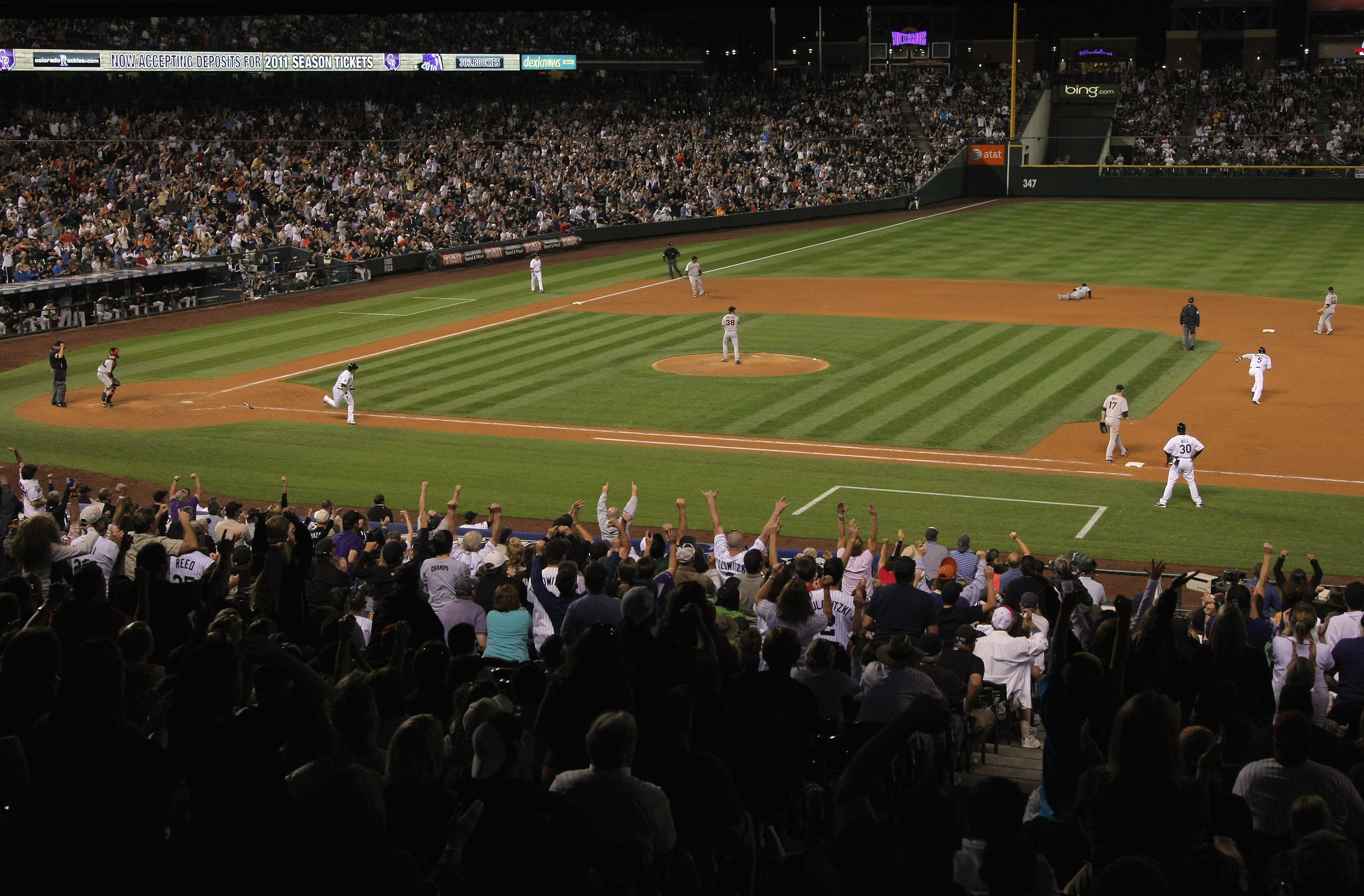 DENVER - SEPTEMBER 25:  The crowd errupts as Troy Tulowitzki #2 of the Colorado Rockies doubles past shortstop Juan Uribe #5 of the San Francisco Giants to score Carlos Gonzalez for the game winning run in the 10th inning at Coors Field on September 25, 2