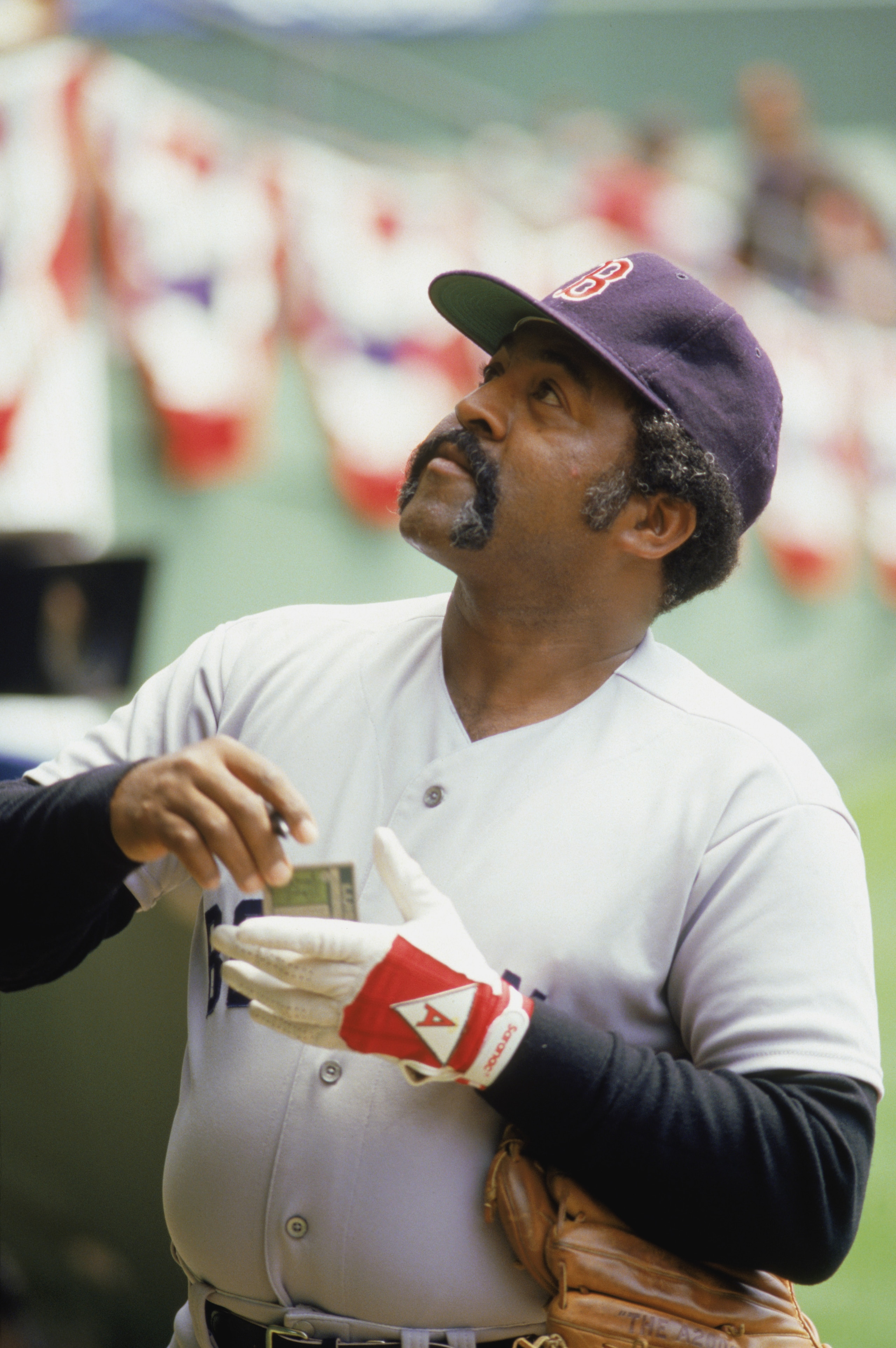 1986:  Former Boston Red Sox player Luis Tiant '71-'78,  signs autograghs before a game during the 1986 season. (Photo by: Stephen Dunn/Getty Images)