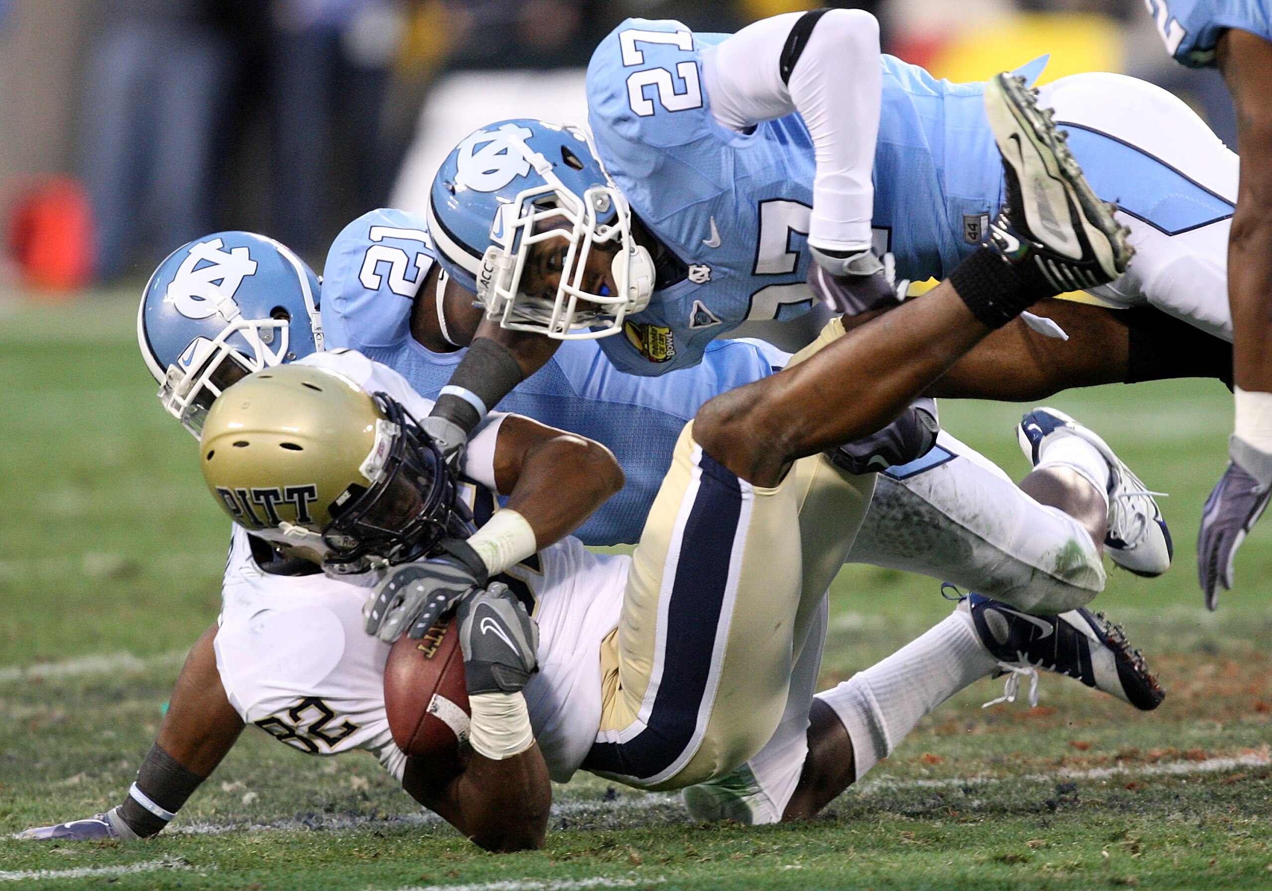 CHARLOTTE, NC - DECEMBER 26: Jonathan Baldwin #82 of the Pittsburgh Panthers is tackled by teammates Da'Norris Searcy #21 and Deunta Williams #27 of the North Carolina Tar Heels during their game on December 26, 2009 in Charlotte, North Carolina. (Photo CHARLOTTE, NC - DECEMBER 26: Jonathan Baldwin #82 of the Pittsburgh Panthers is tackled by teammates Da'Norris Searcy #21 and Deunta Williams #27 of the North Carolina Tar Heels during their game on December 26, 2009 in Charlotte, North Carolina. (Photo