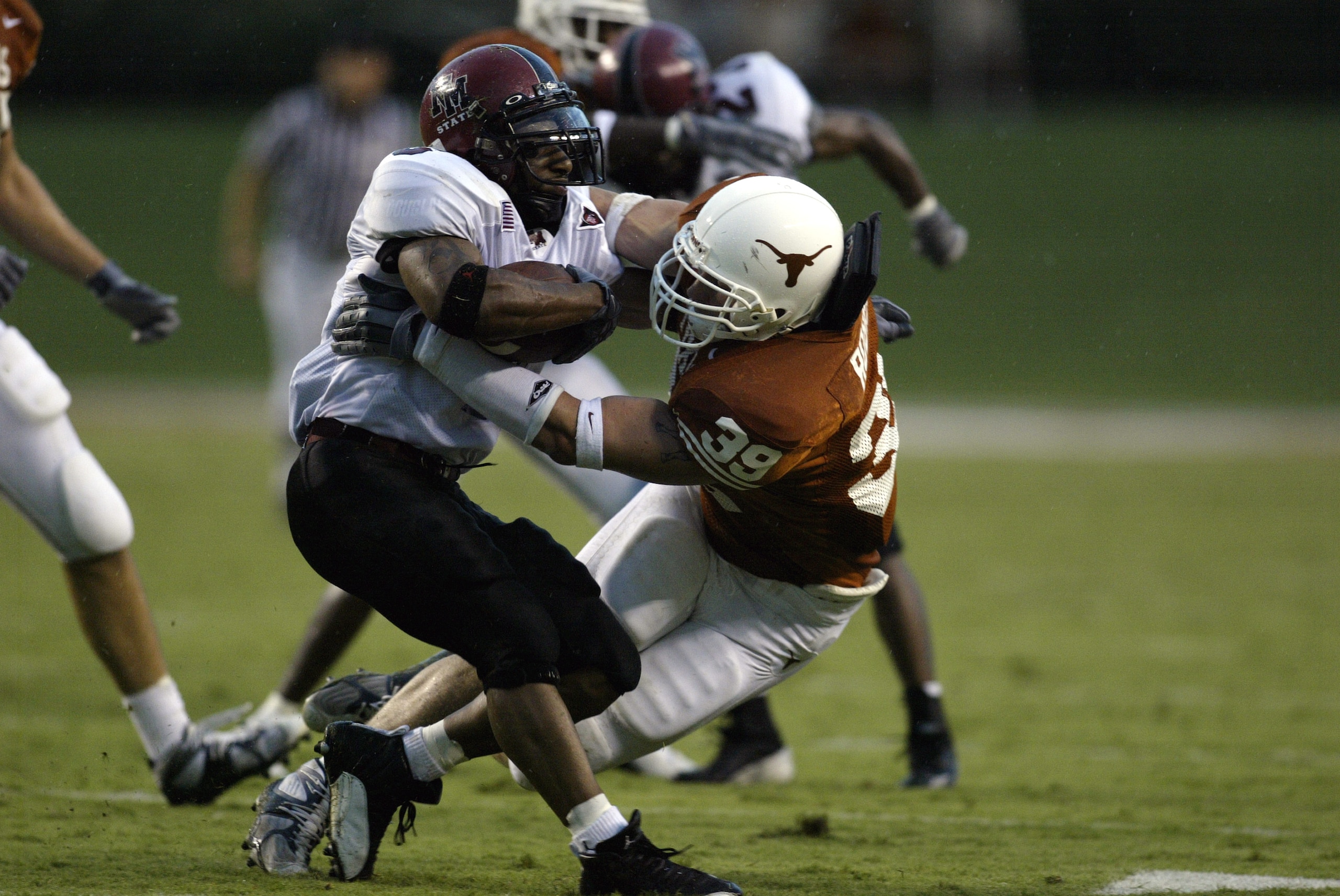 AUSTIN, TX - AUGUST 31:  Linebacker Brian Robison #39 of the University of Texas at Austin Longhorns tackles Keith Mouton #6 of the New Mexico State University Aggies at Texas Memorial Stadium on August 31, 2003 in Austin, Texas. Texas defeated New Mexico