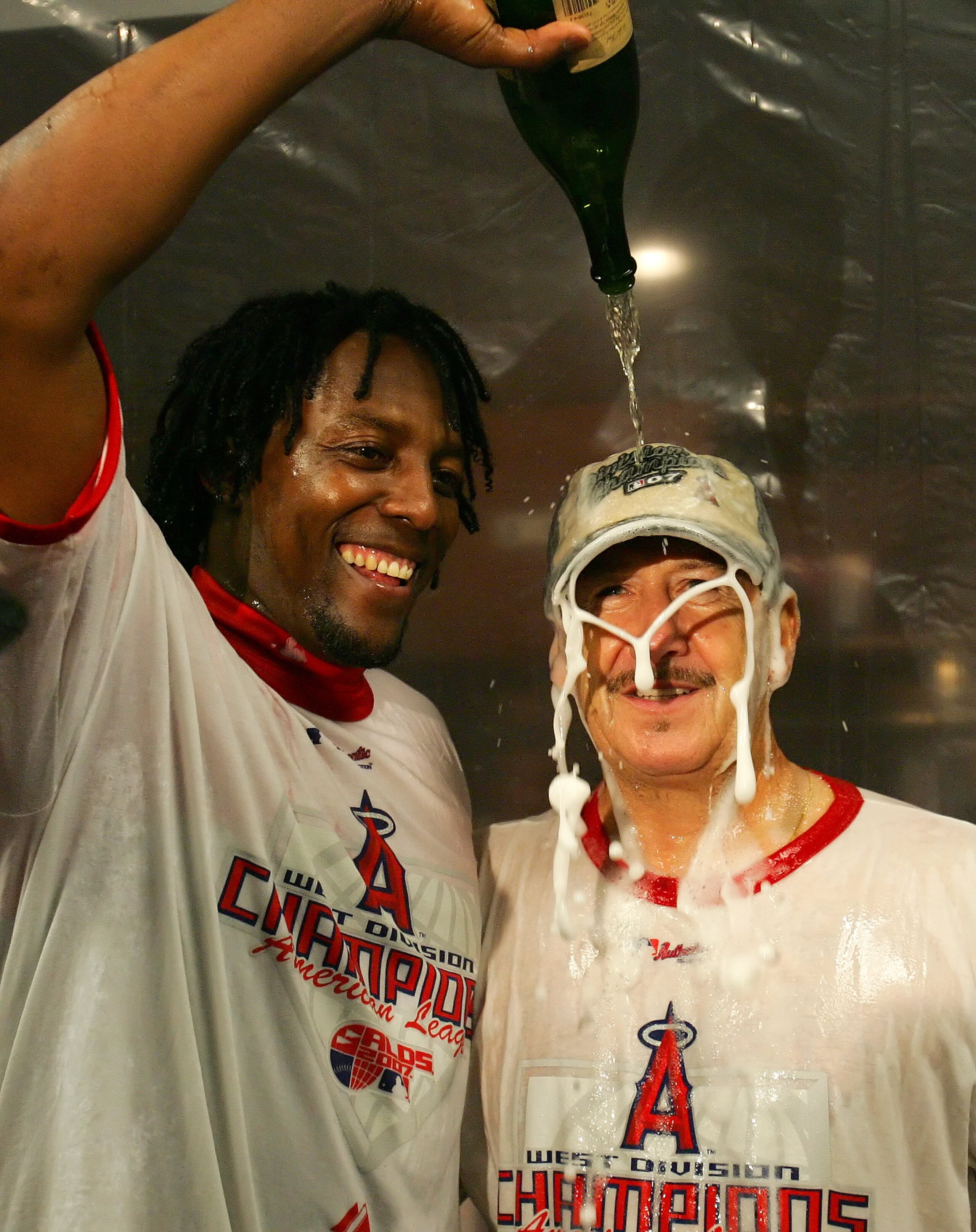 ANAHEIM, CA - SEPTEMBER 23:   (L-R) Vladimir Guerrero #27 celebrates with team owner Arte Moreno of the Los Angeles Angels of Anaheim in the locker room after defeating the Seattle Mariners 7-4 to win the American League Western Division at Angels Stadium