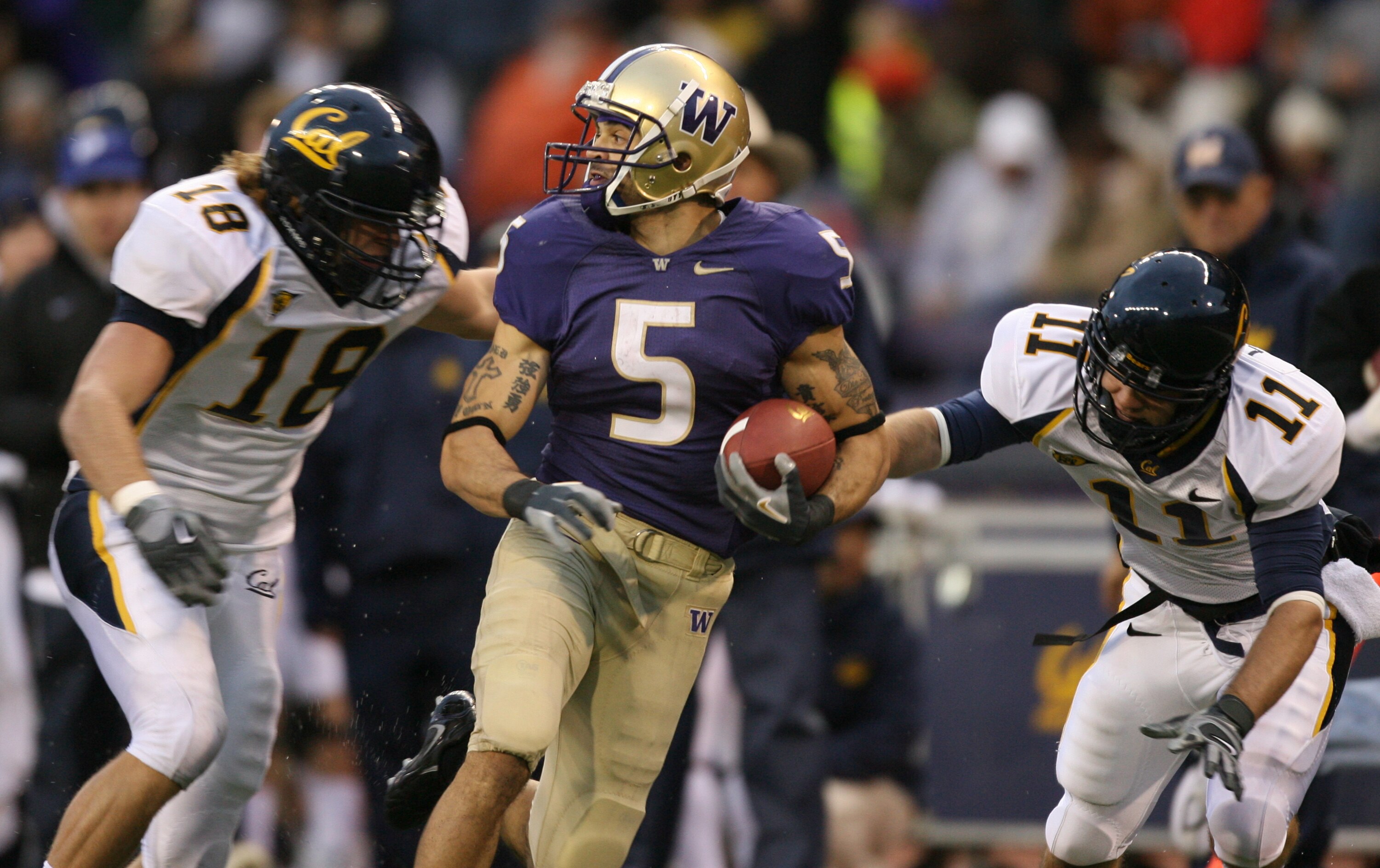 SEATTLE - NOVEMBER 17:  Wide receiver Anthony Russo #5 of the Washington Huskies returns a punt for 62 yards against  Michael Mohamed #18 and Andrew Larson #11 of the California Golden Bears at Husky Stadium November 17, 2007 in Seattle, Washington. The H