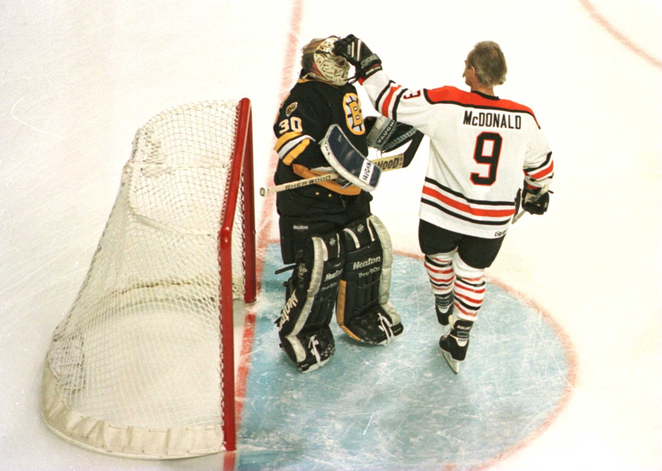 19 Jan 1996:  Lanny McDonald #9 of the NHL Heroes gives a friendly pat to the mask of goalie Gerry Cheevers #30 of the Boston Bruins Heroes during the first period of the NHL Heroes of Hockey game played at the Fleet Center in Boston, Massachusetts. Manda