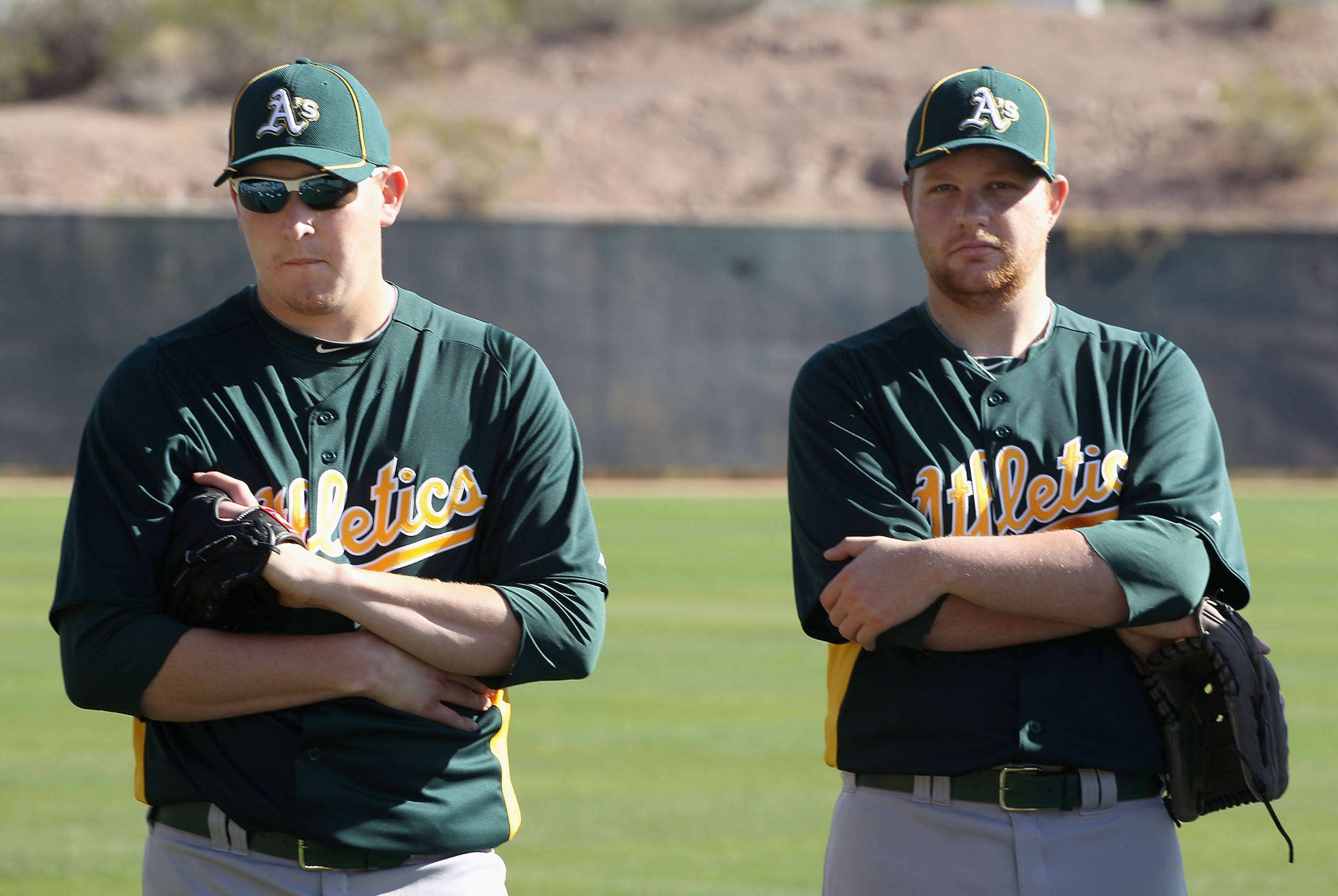 PHOENIX, AZ - FEBRUARY 16:  (L-R) Pitchers Trevor Cahill #53 and Brett Anderson #49 of the Oakland Athletics warm up during a MLB spring training practice at Phoenix Municipal Stadium on February 16, 2011 in Phoenix, Arizona.  (Photo by Christian Petersen