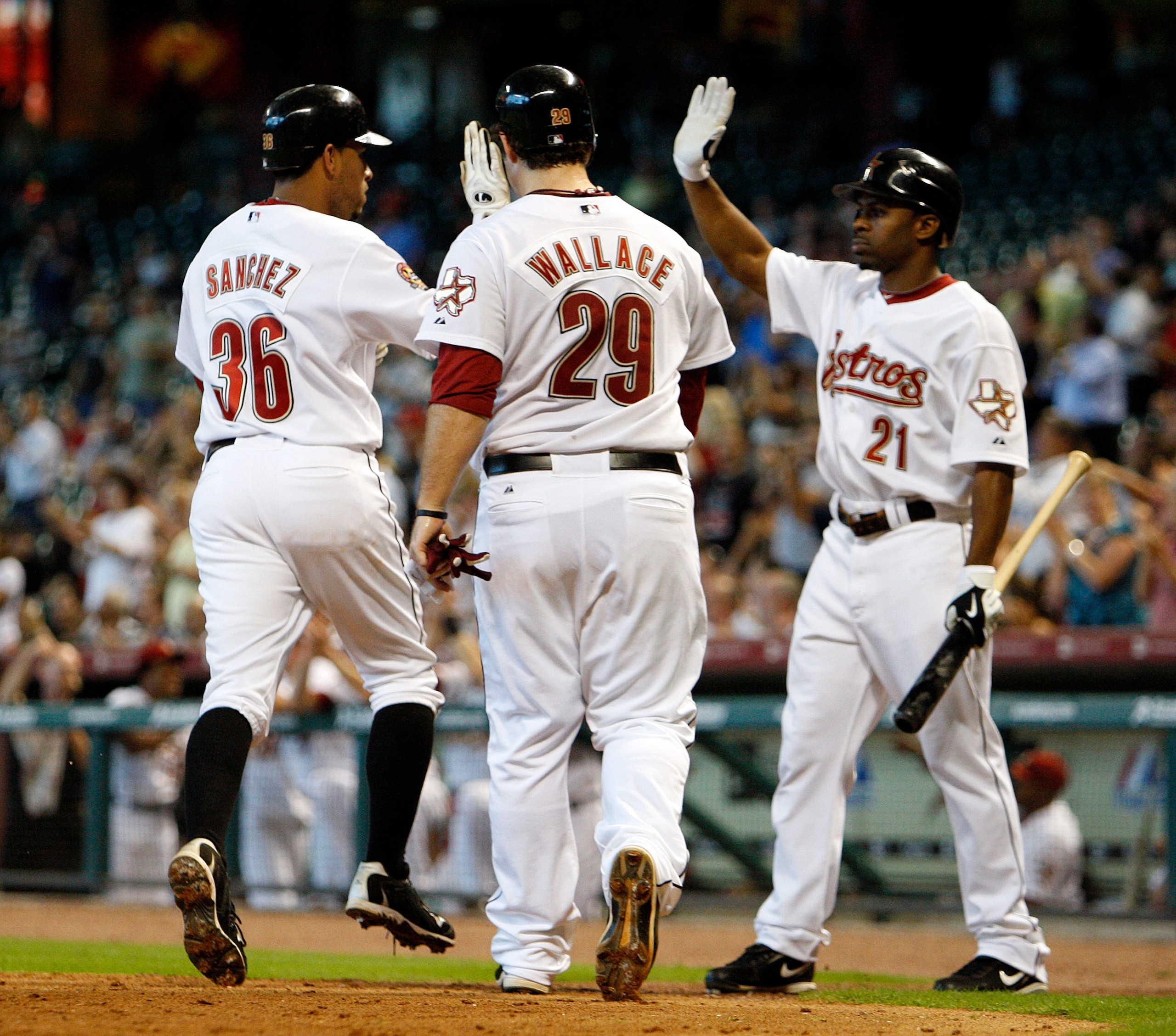 HOUSTON - SEPTEMBER 15:  Angel Sanchez #36 and Brett Wallace #29 of the Houston Astros score on a single by Brian Bogusevic of the Houston Astros in the fifth inning as Micahael Bourn greets  them at home plate during a baseball game against the Milwaukee