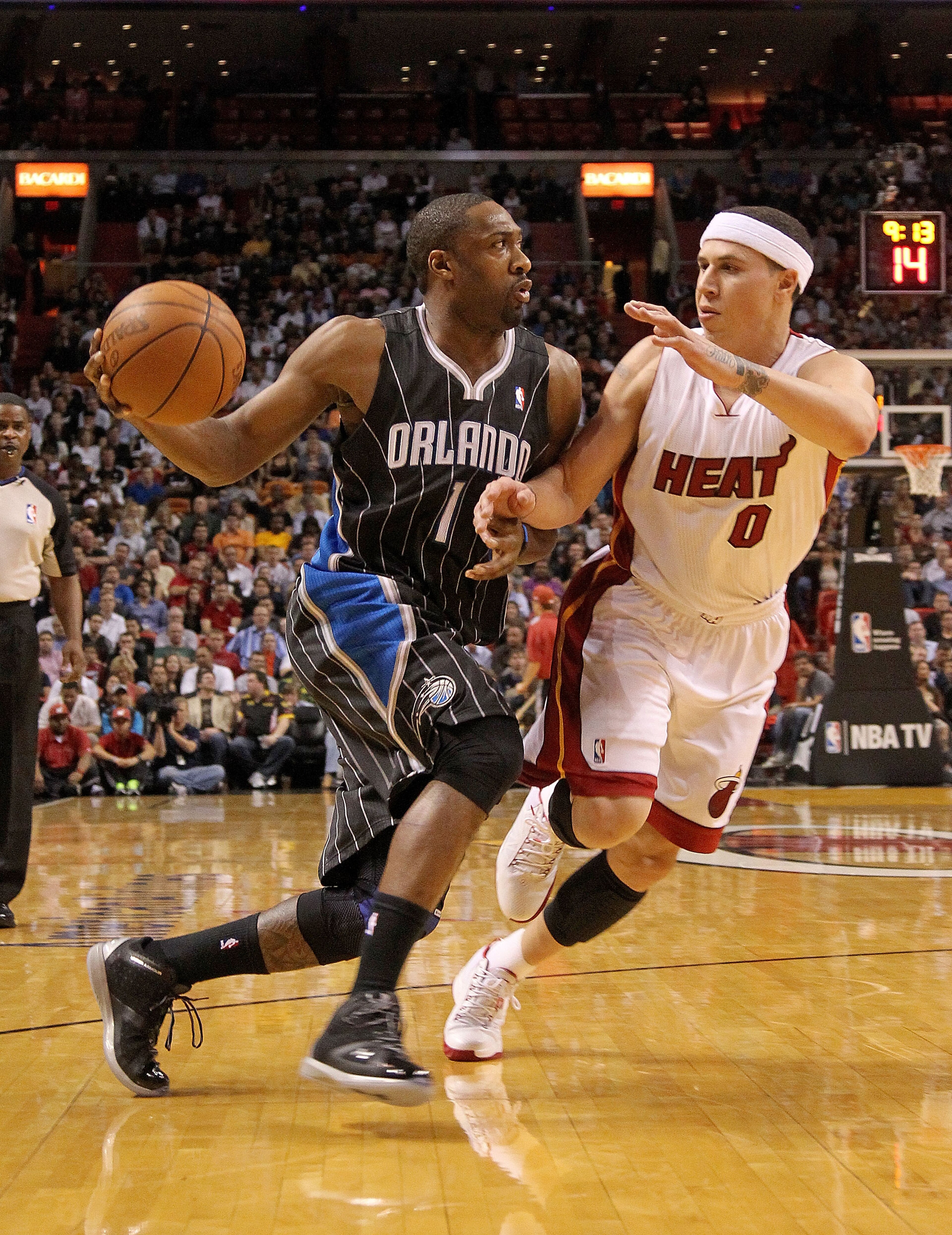 MIAMI, FL - MARCH 03: Gilbert Arenas #1 of the Orlando Magic drives against Mike Bibby #0 of the Miami Heat during a game at American Airlines Arena on March 3, 2011 in Miami, Florida. NOTE TO USER: User expressly acknowledges and agrees that, by download