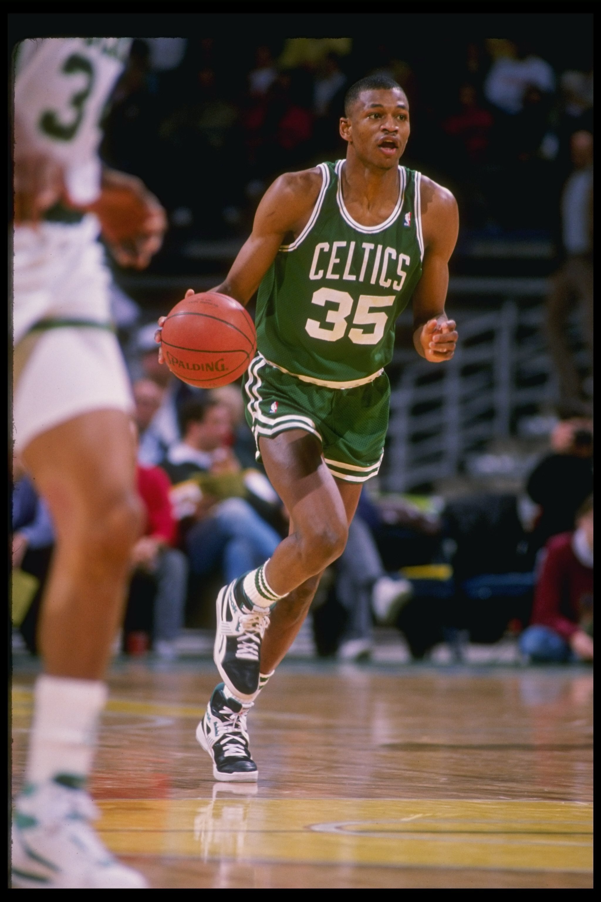 Guard Reggie Lewis of the Boston Celtics dribbles the ball down the court during a game against the Milwaukee Bucks at the Bradley Center in Milwaukee, Wisconsin.