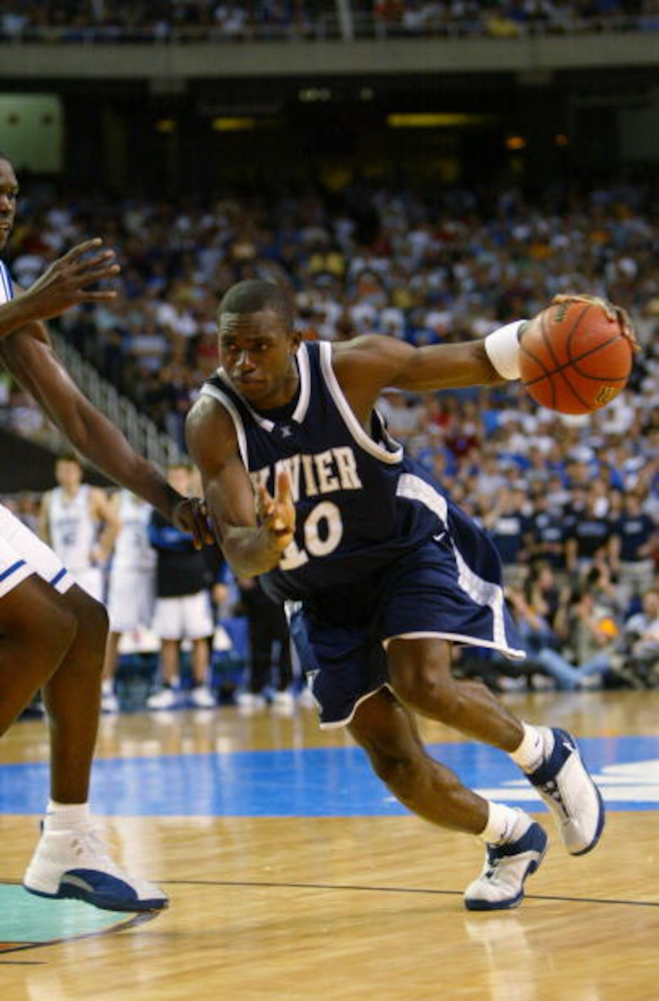 ATLANTA - MARCH 28:  Romain Sato #10 of the Xavier Musketeers drives against the Duke Blue Devils during the fourth round game of the NCAA Division I Men's Basketball Tournament at the Georgia Dome on March 28, 2004 in Atlanta, Georgia.  The Blue Devils w