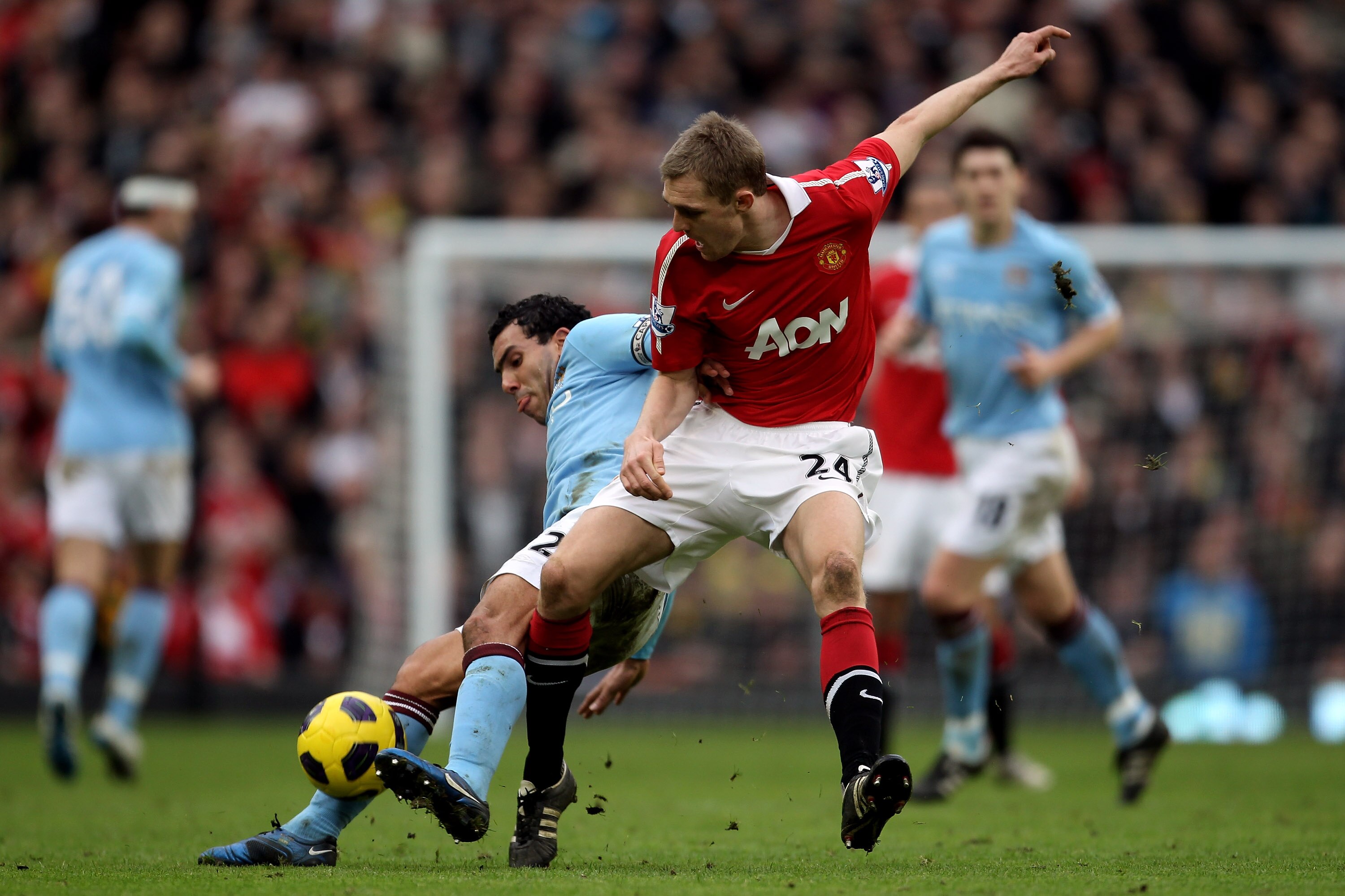 MANCHESTER, ENGLAND - FEBRUARY 12:  Carlos Tevez (L) of Manchester City in action against Darren Fletcher of Manchester United during the Barclays Premier League match between Manchester United and Manchester City at Old Trafford on February 12, 2011 in M