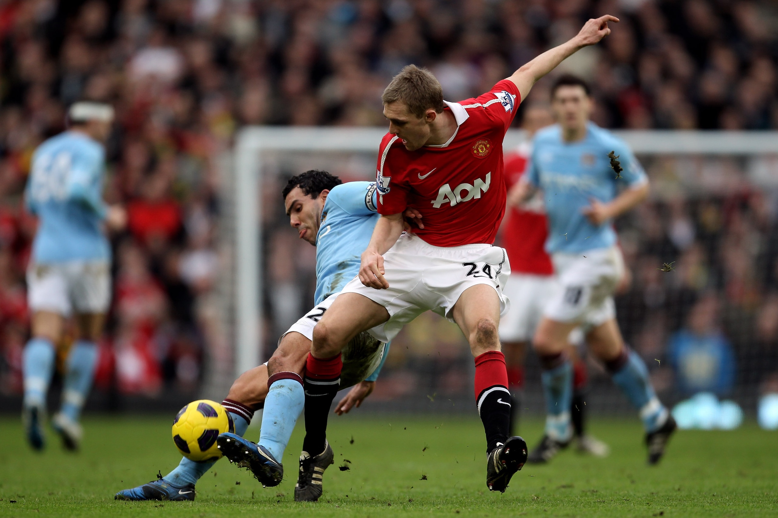 MANCHESTER, ENGLAND - FEBRUARY 12:  Carlos Tevez (L) of Manchester City in action against Darren Fletcher of Manchester United during the Barclays Premier League match between Manchester United and Manchester City at Old Trafford on February 12, 2011 in M
