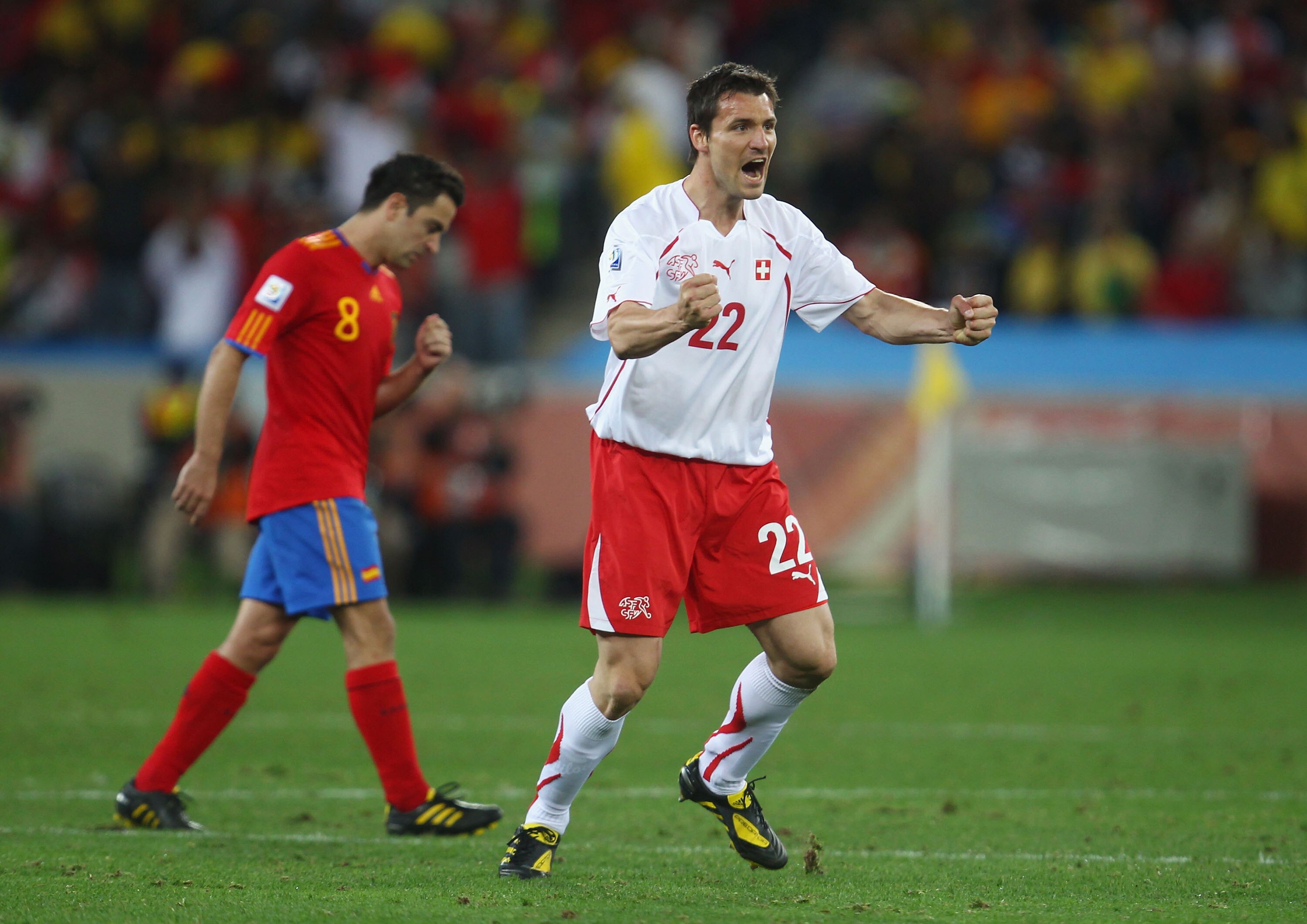 DURBAN, SOUTH AFRICA - JUNE 16:  Mario Eggimann of Switzerland celebrates as Xavi Hernandez of Spain walks by dejected during the 2010 FIFA World Cup South Africa Group H match between Spain and Switzerland at Durban Stadium on June 16, 2010 in Durban, So