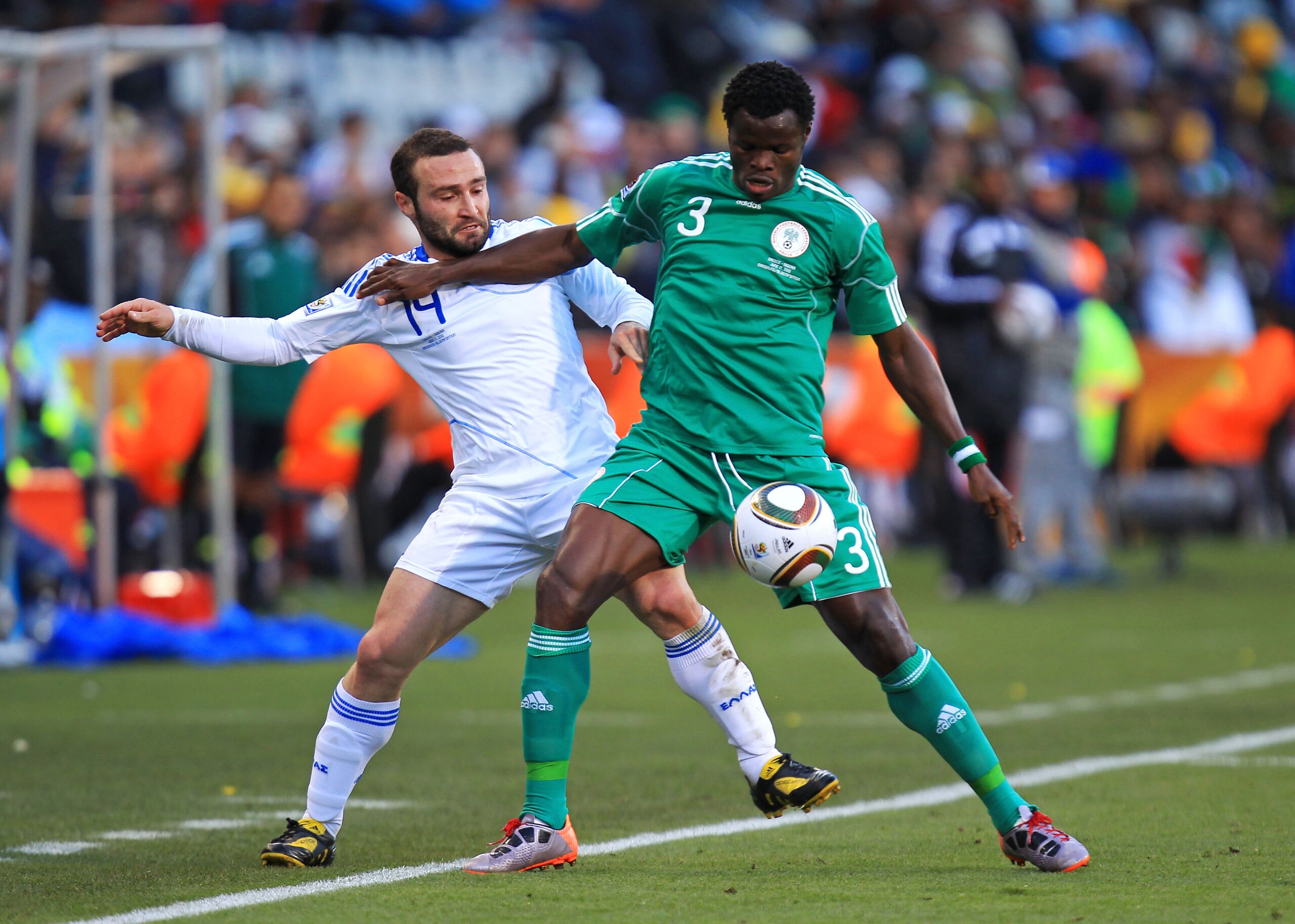 BLOEMFONTEIN, SOUTH AFRICA - JUNE 17: Taye Taiwo of Nigeria holds off Dimitrios Salpingidis of Greece during the 2010 FIFA World Cup South Africa Group B match between Greece and Nigeria at the Free State Stadium on June 17, 2010 in Mangaung/Bloemfontein,