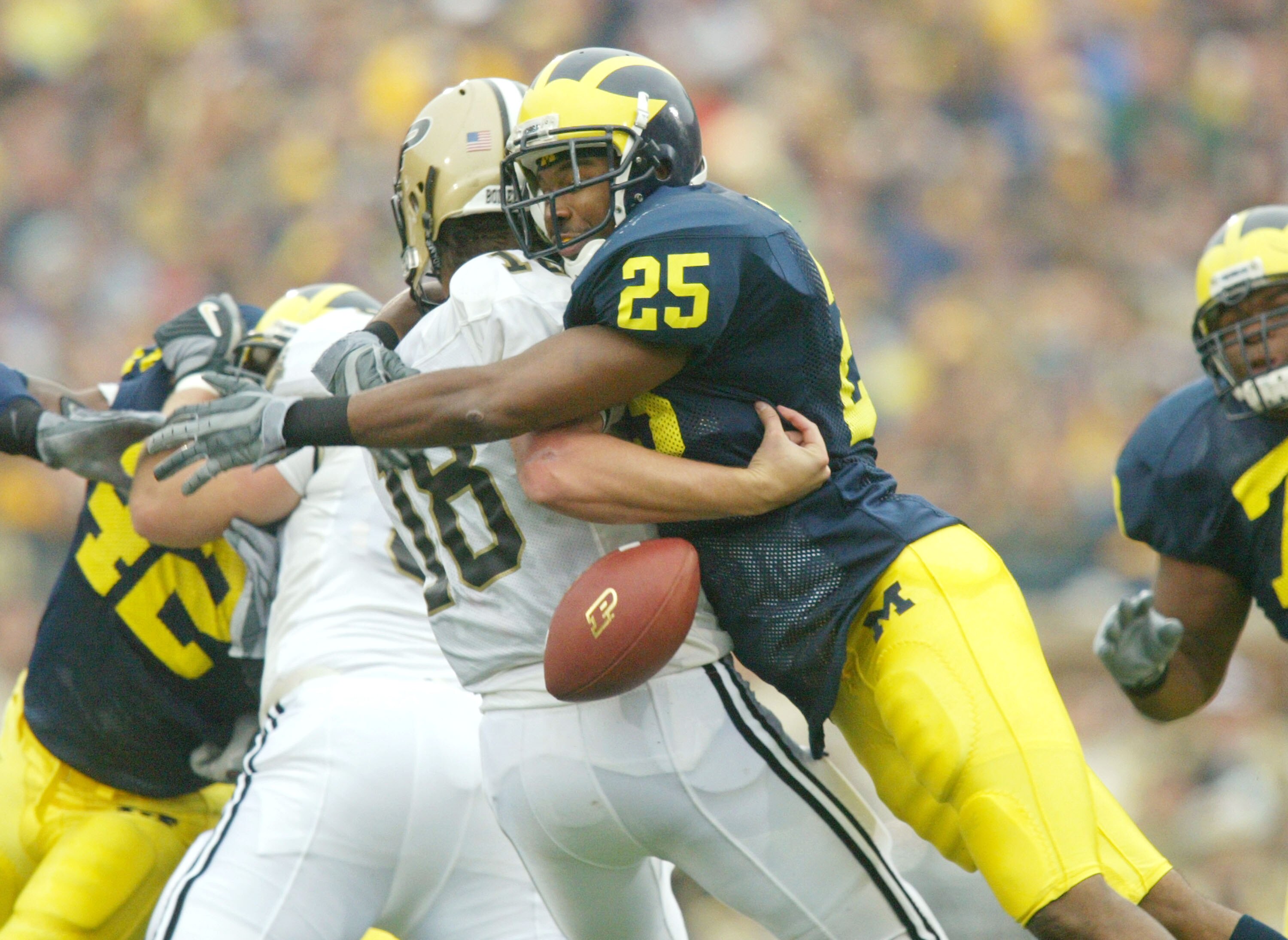 ANN ARBOR, MI - OCTOBER 25:  Ernest Shazor #25 of the Michigan Wolverines hits quarterback Kyle Orton #18 of the Purdue Boilermakers and causes a fumble on October 25, 2003 at Michigan Stadium in Ann Arbor, Michigan. Purdue recovered the fumble.  (Photo b