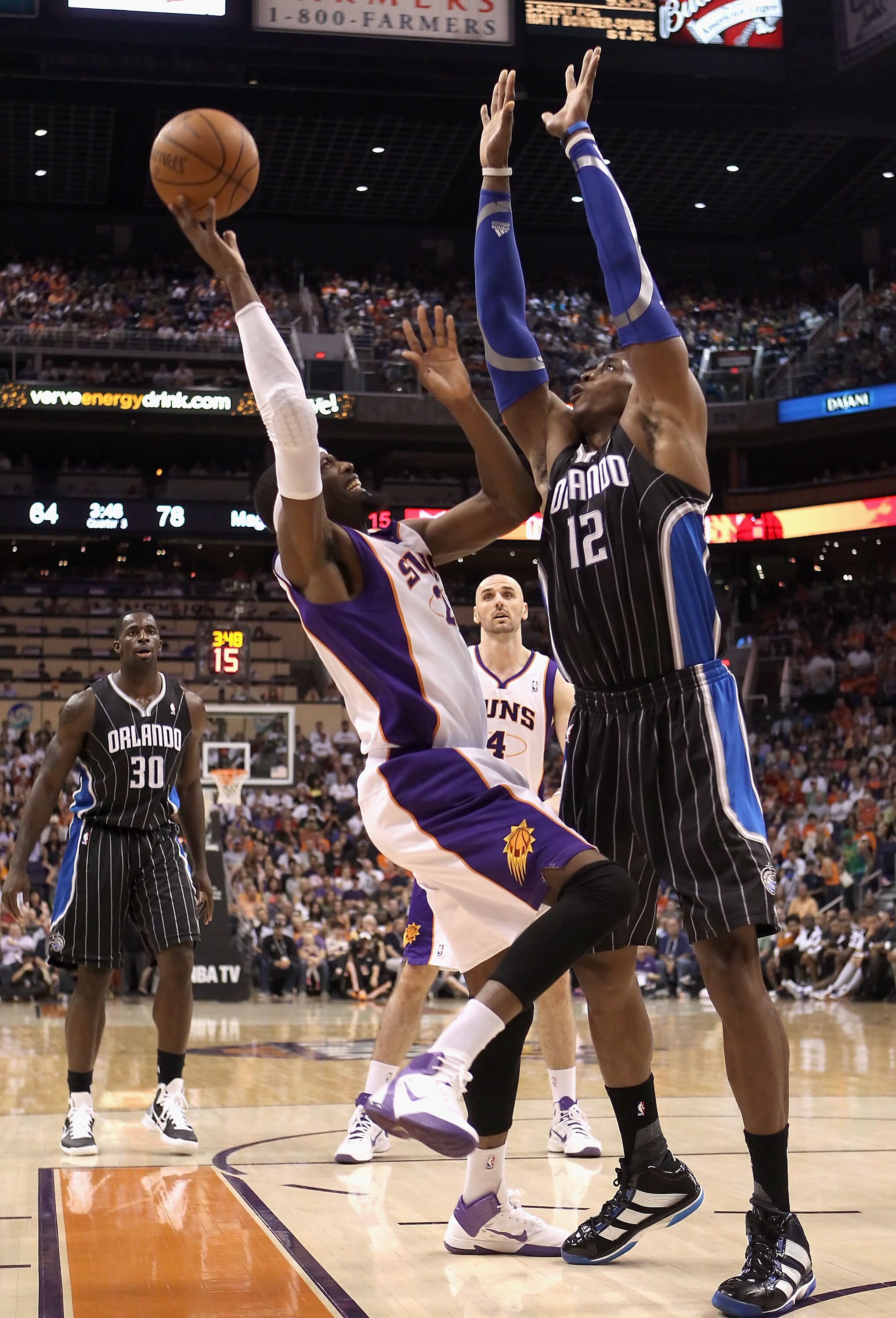 PHOENIX, AZ - MARCH 13:  Hakim Warrick #21 of the Phoenix Suns attempts a shot over Dwight Howard  #12 of the Orlando Magic during the NBA game at US Airways Center on March 13, 2011 in Phoenix, Arizona. The Magic defeated the Suns 111-88.  NOTE TO USER: