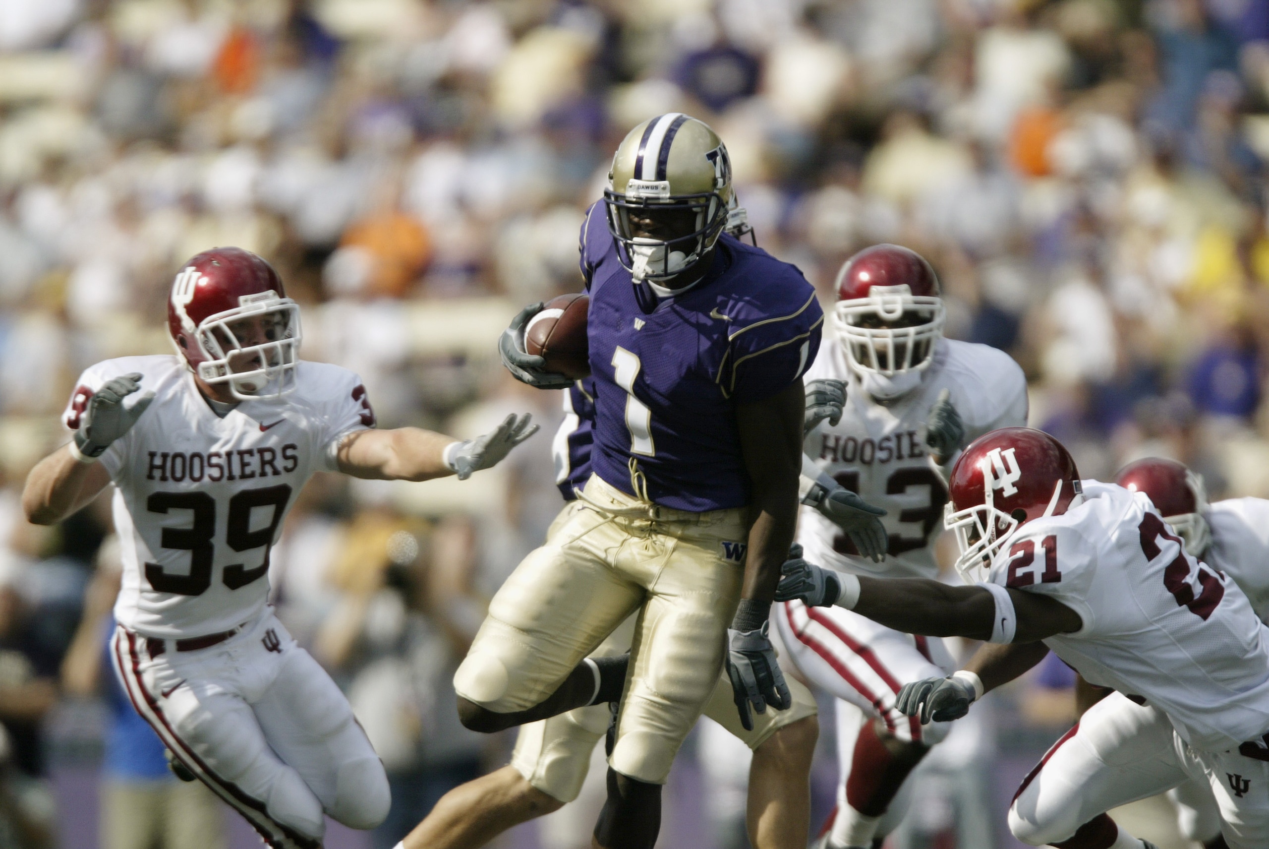SEATTLE - SEPTEMBER 6:  Wide receiver Reggie Williams #1 of the University of Washington Huskies breaks free from defenders tackle for a 70-yard touchdown against the University of Indiana Hoosiers on September 6, 2003 at Husky Stadium in Seattle, Washing