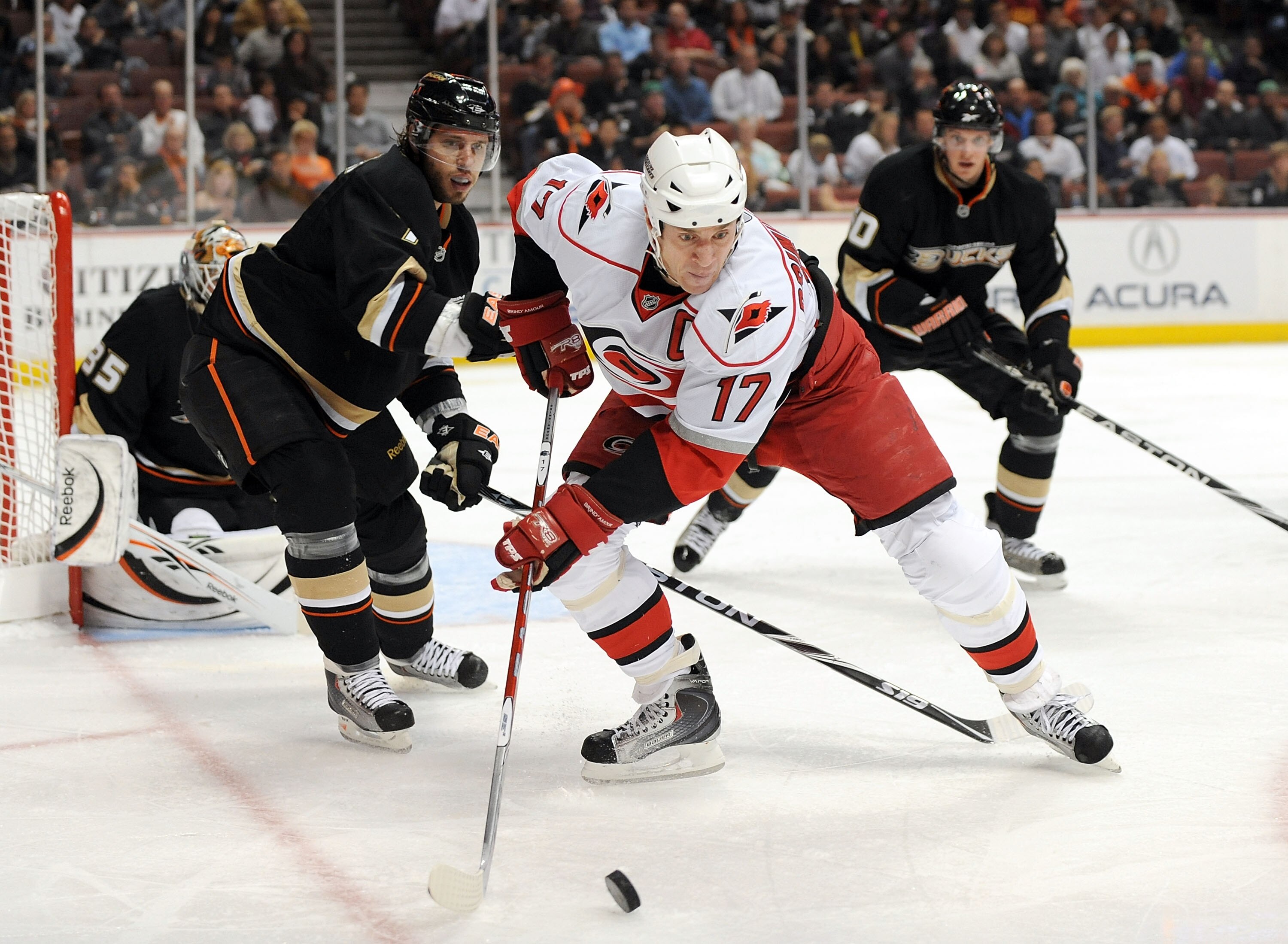 ANAHEIM, CA - NOVEMBER 25:  Rod Brind'Amour #17 of the Carolina Hurricanes takes a pass in front of Steve Eminger #7 and Corey Perry #10 of the Anaheim Ducks during the second period at the Honda Center on November 25, 2009 in Anaheim, California.  (Photo