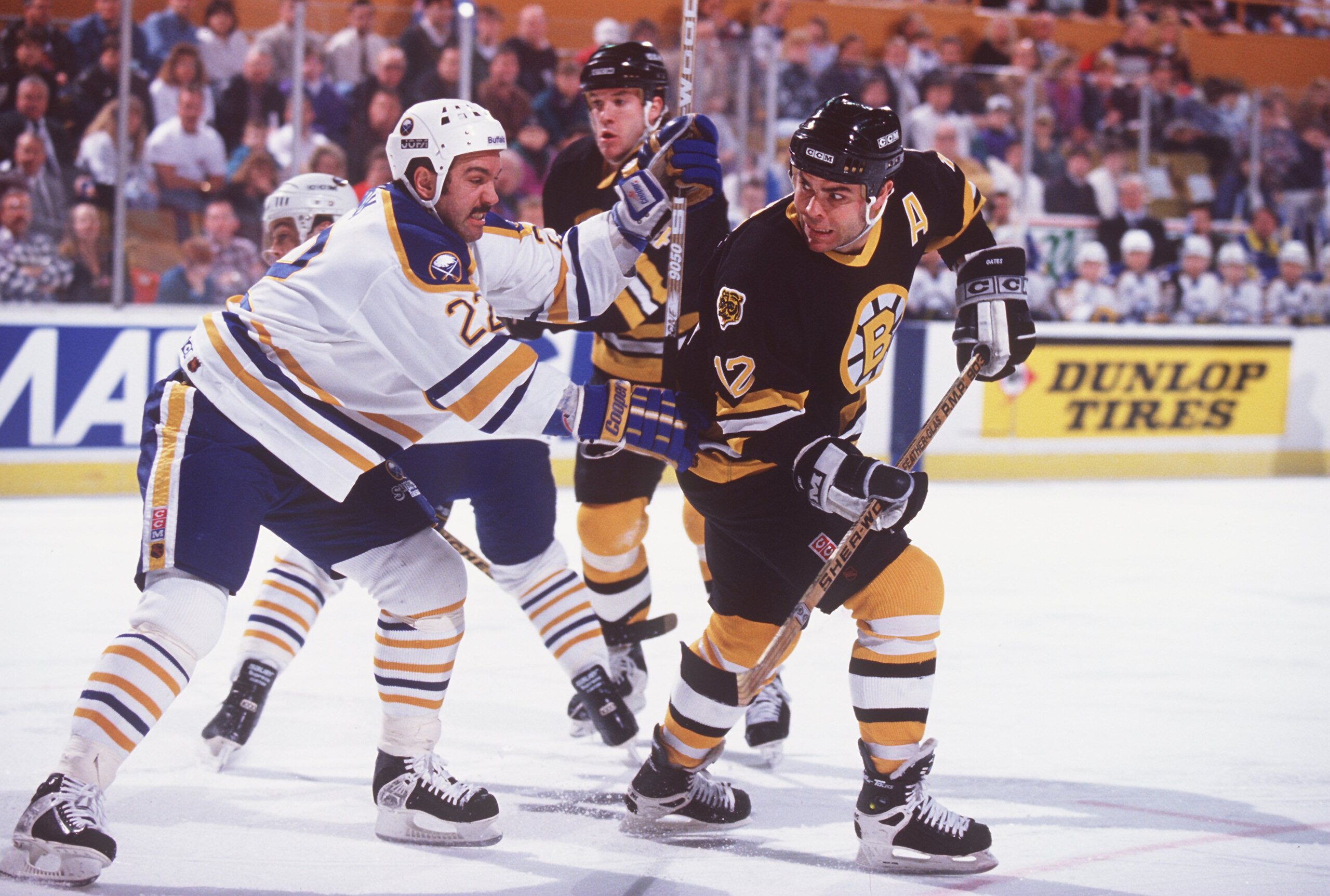 9 APR 1995:  ADAM OATES OF BOSTON IS CHECKED FROM BEHIND BY BUFFALO DEFENSEMAN CHARLIE HUDDY DURING THE BRUINS GAME VERSUS THE BUFFALO SABRES AT THE AUD IN BUFFALO, NEW YORK. Mandatory Credit: Rick Stewart/ALLSPORT