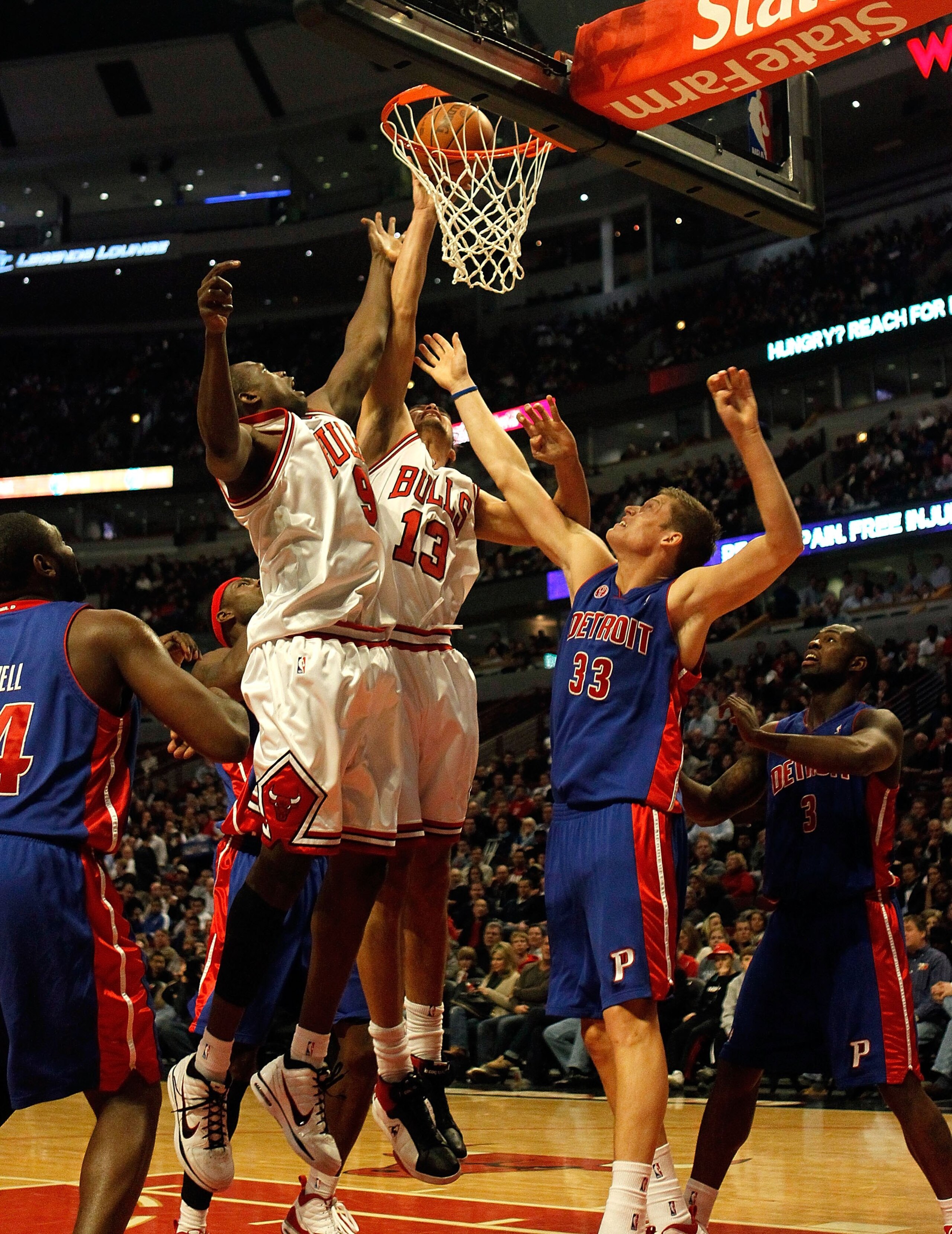 CHICAGO - DECEMBER 02: Loul Deng #9 and Joakim Noah #13 of the Chicago Bulls jump for a rebound over Jonas Jerebko #33 of the Detroit Pistons at the United Center on December 2, 2009 in Chicago, Illinois. The Bulls defeated the Pistons 92-85. NOTE TO USER