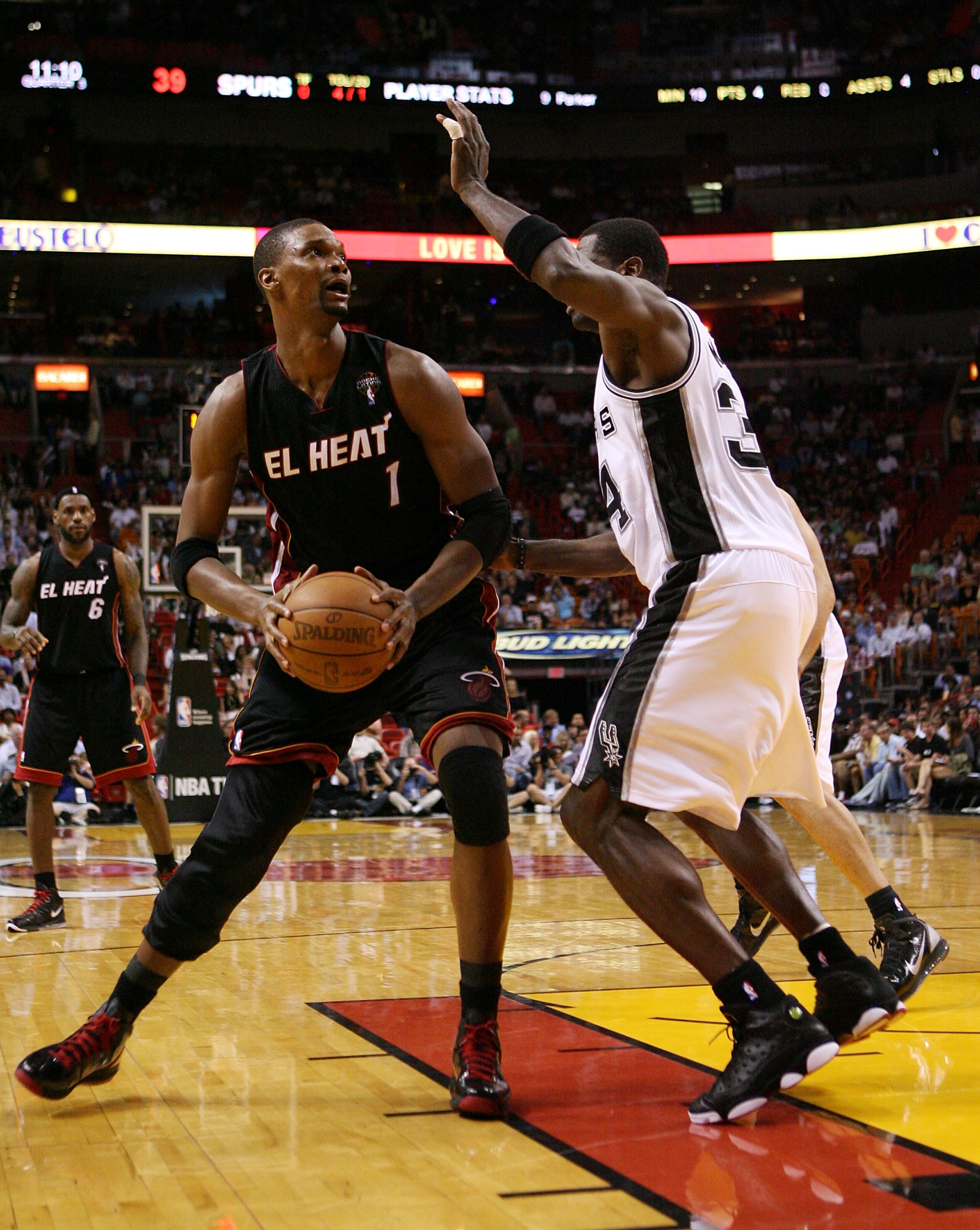 MIAMI - MARCH 14:  Forward Chris Bosh #1 of the Miami Heat drives against DeJuan Blair #34 of the San Antonio Spurs at American Airlines Arena on March 14, 2011 in Miami, Florida. The Heat defeated the Spurs 110-80. NOTE TO USER: User expressly acknowledg