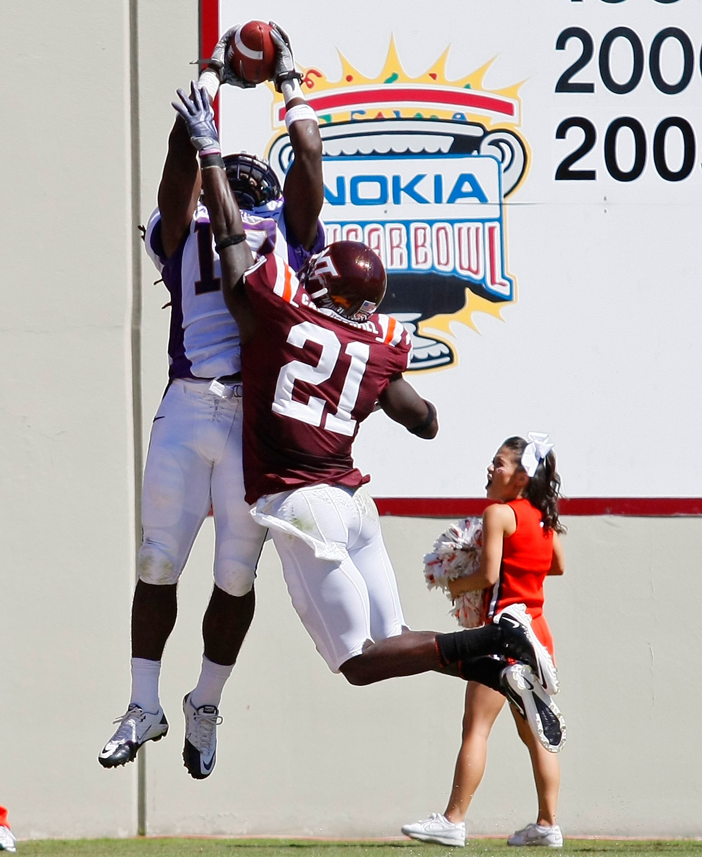 BLACKSBURG, VA - SEPTEMBER 18:  Wide receiver Dwayne Harris #17 of the East Carolina Pirates leaps to catch a pass for a touchdown over cornerback Rashad Carmichael #21 of the Virginia Tech Hokies at Lane Stadium on September 18, 2010 in Blacksburg, Virgi