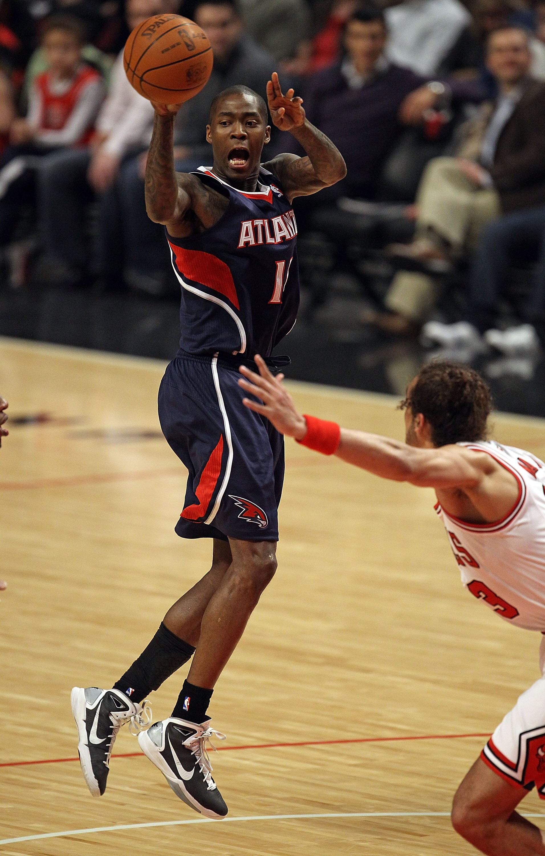 CHICAGO, IL - MARCH 11: Jamal Crawford #11 of the Atlanta Hawks leaps to pass over Joakim Noah #13 of the Chicago Bulls at the United Center on March 11, 2011 in Chicago, Illinois. NOTE TO USER: User expressly acknowledges and agrees that, by downloading