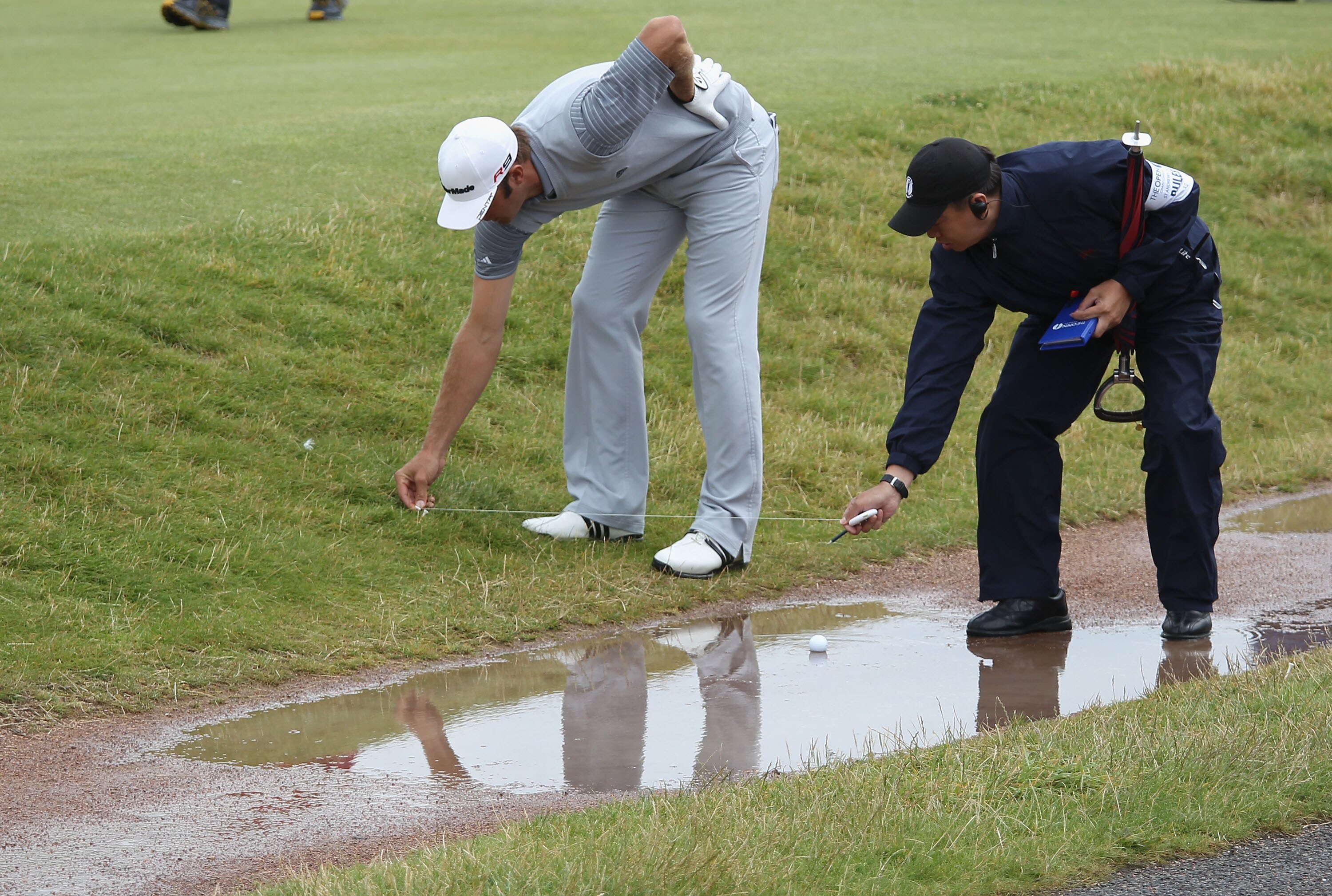 ST ANDREWS, SCOTLAND - JULY 16:  Dustin Johnson of the USA gets a ruling on the 17th hole during the second round of the 139th Open Championship on the Old Course, St Andrews on July 16, 2010 in St Andrews, Scotland.  (Photo by Ross Kinnaird/Getty Images)