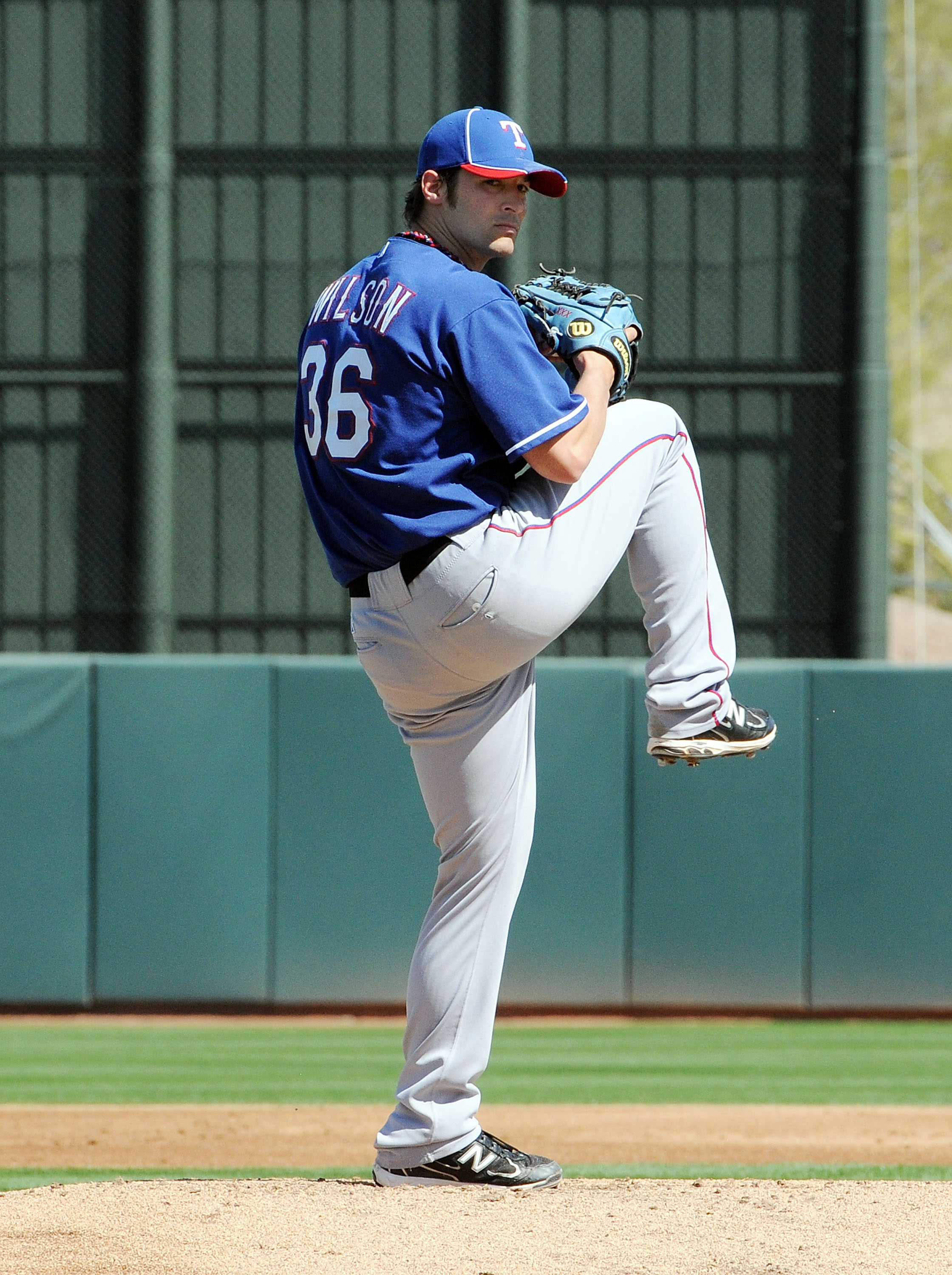PHOENIX, AZ - MARCH 04:  C.J. Wilson #36 of the Texas Rangers delivers a pitch against the Oakland Athletics at Phoenix Municipal Stadium on March 4, 2011 in Phoenix, Arizona.  (Photo by Norm Hall/Getty Images)