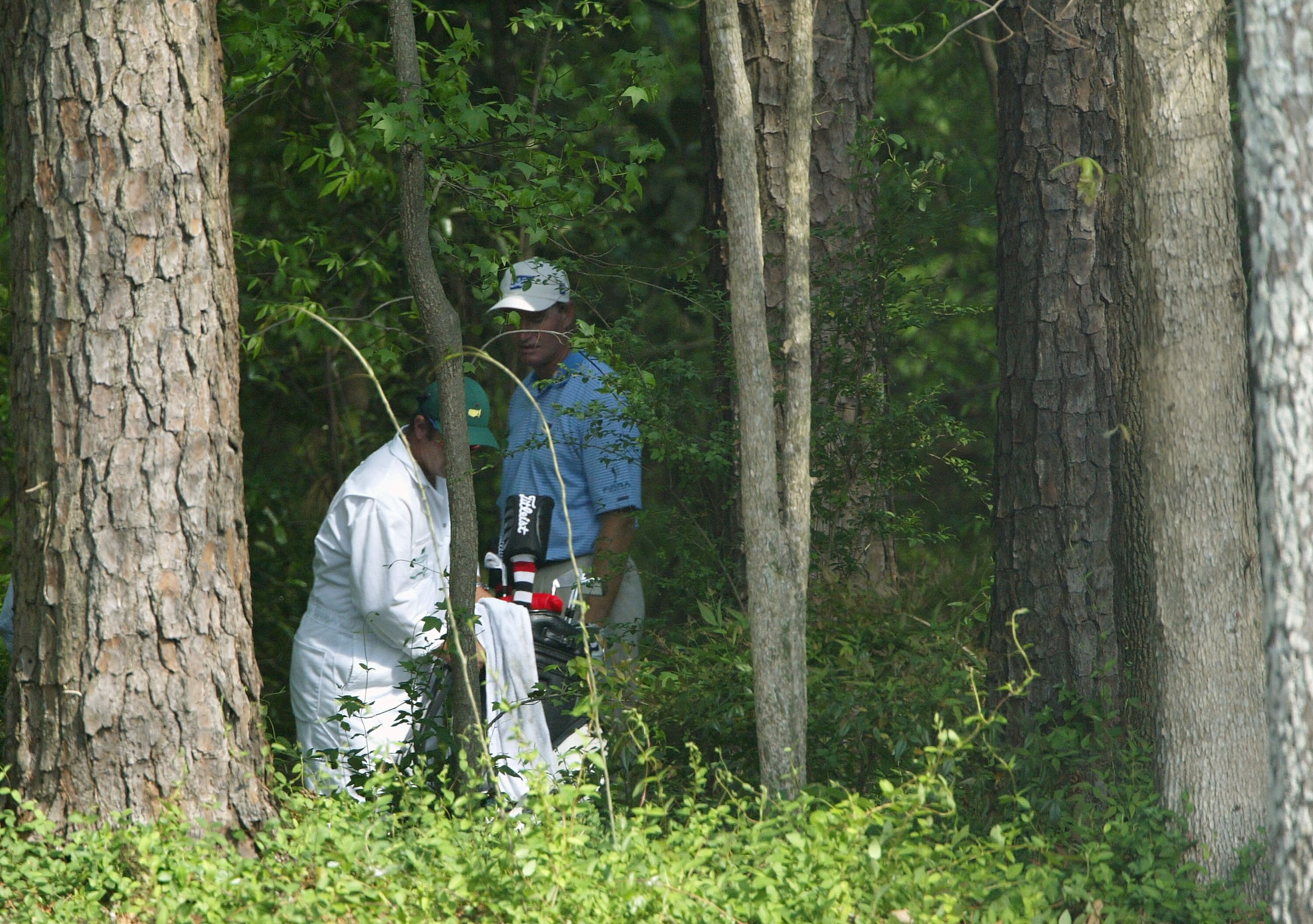 AUGUSTA, GA - APRIL 10:  Ernie Els of South Africa along with his caddie Ricci Roberts look over a shot from the trees on the 11th hole during the third round of the Masters at the Augusta National Golf Club on April 10, 2004 in Augusta, Georgia.  (Photo