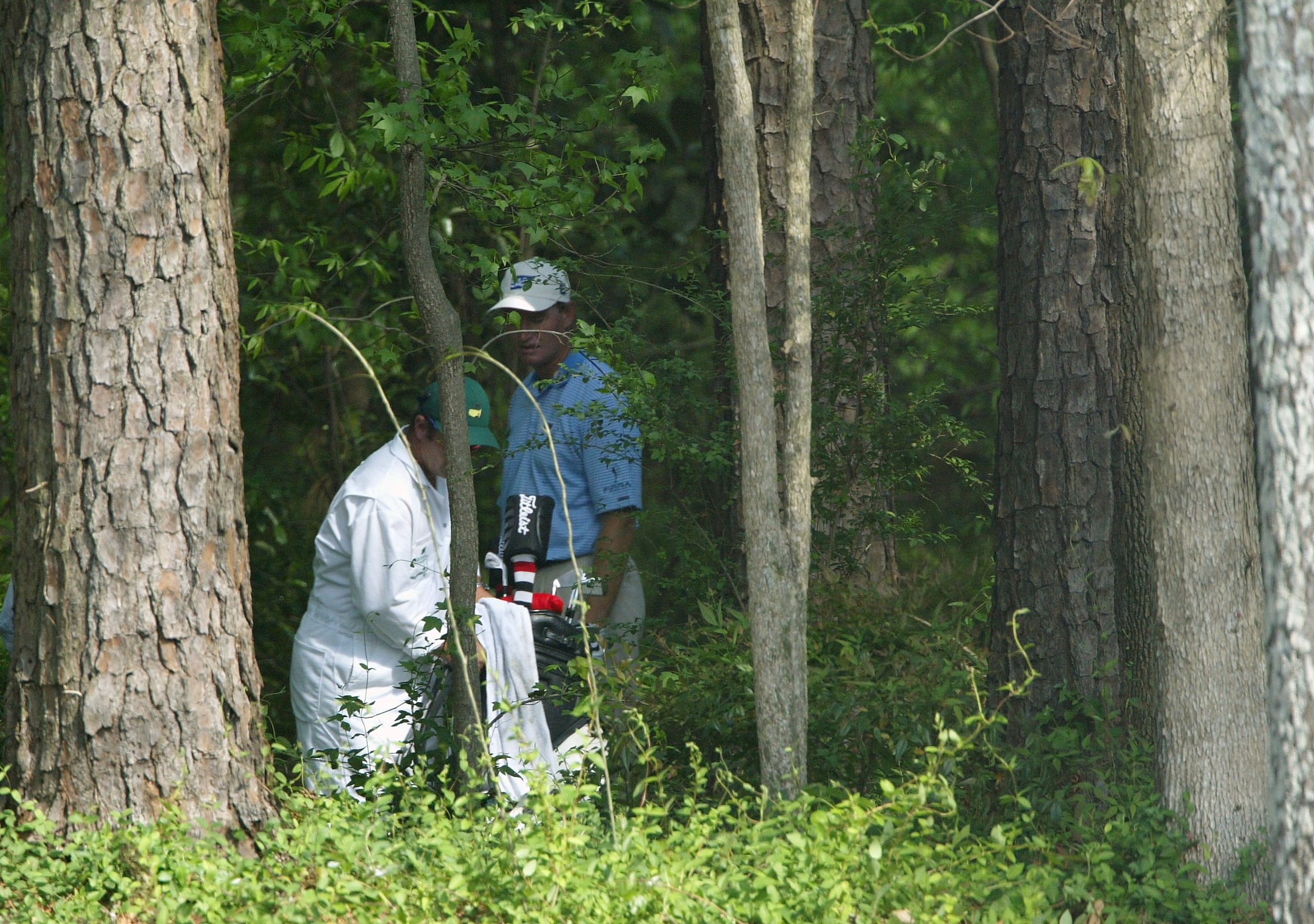 AUGUSTA, GA - APRIL 10:  Ernie Els of South Africa along with his caddie Ricci Roberts look over a shot from the trees on the 11th hole during the third round of the Masters at the Augusta National Golf Club on April 10, 2004 in Augusta, Georgia.  (Photo
